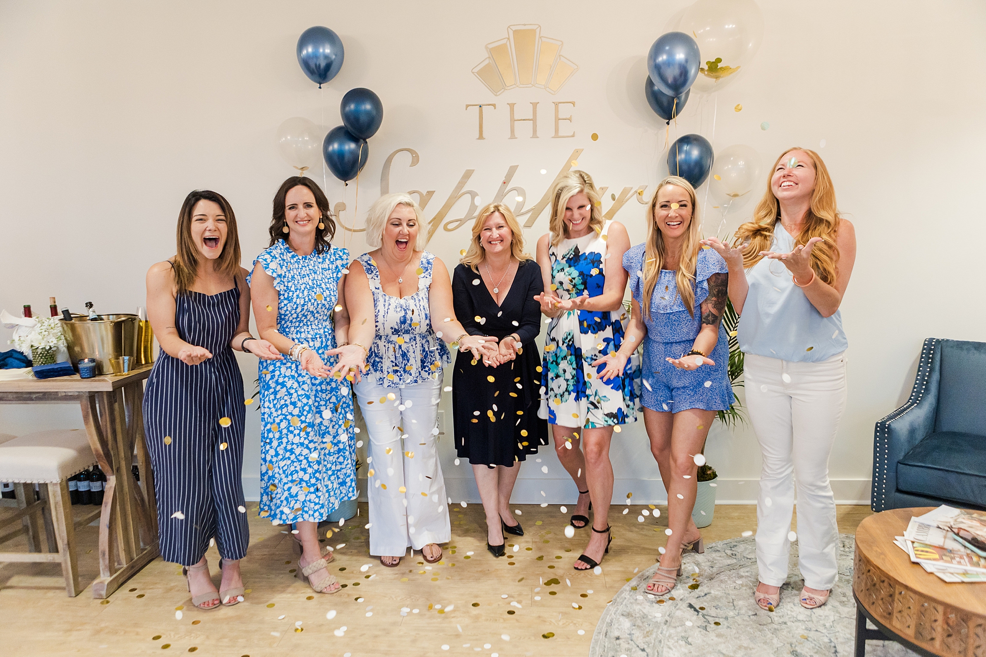 women stand together in blue and white outfits at The Sapphire Suite