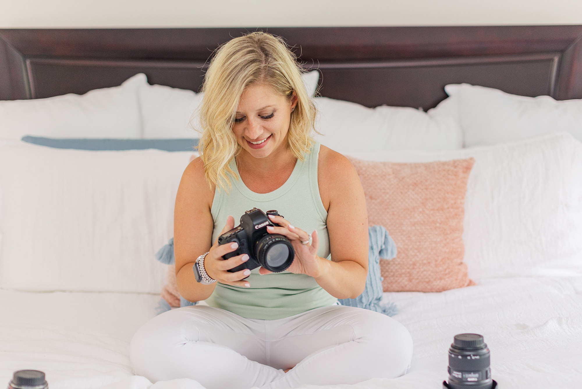 woman sits on bed looking at camera