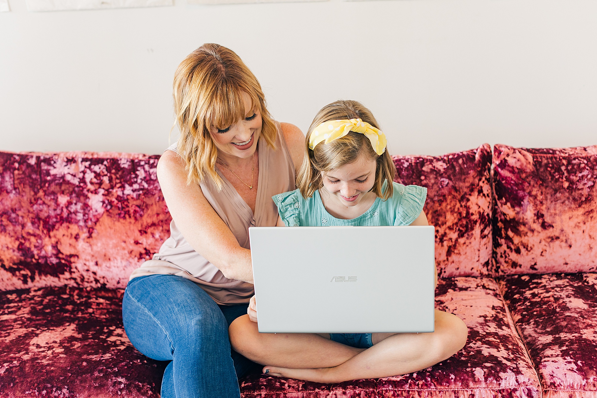 mom shows daughter something on laptop during branding session