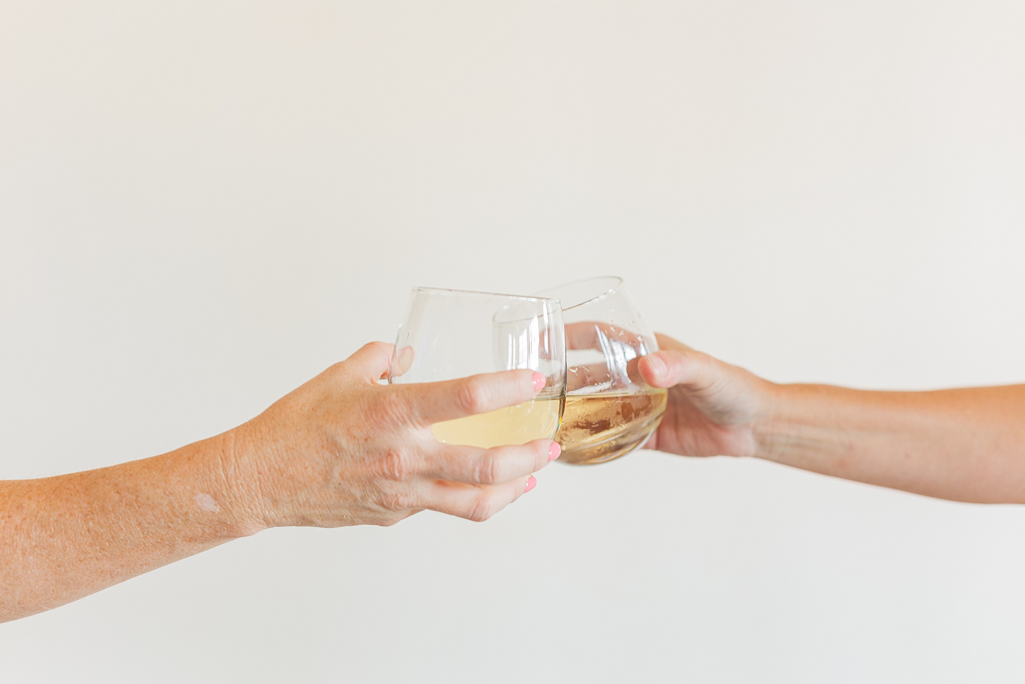 women toast wine glasses