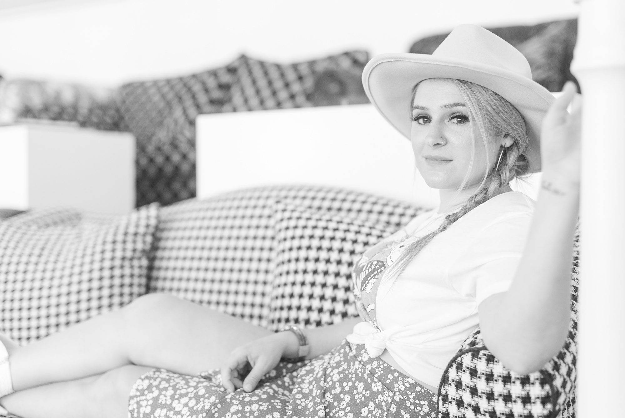 singer sits on plaid couch at the Graduate Hotel