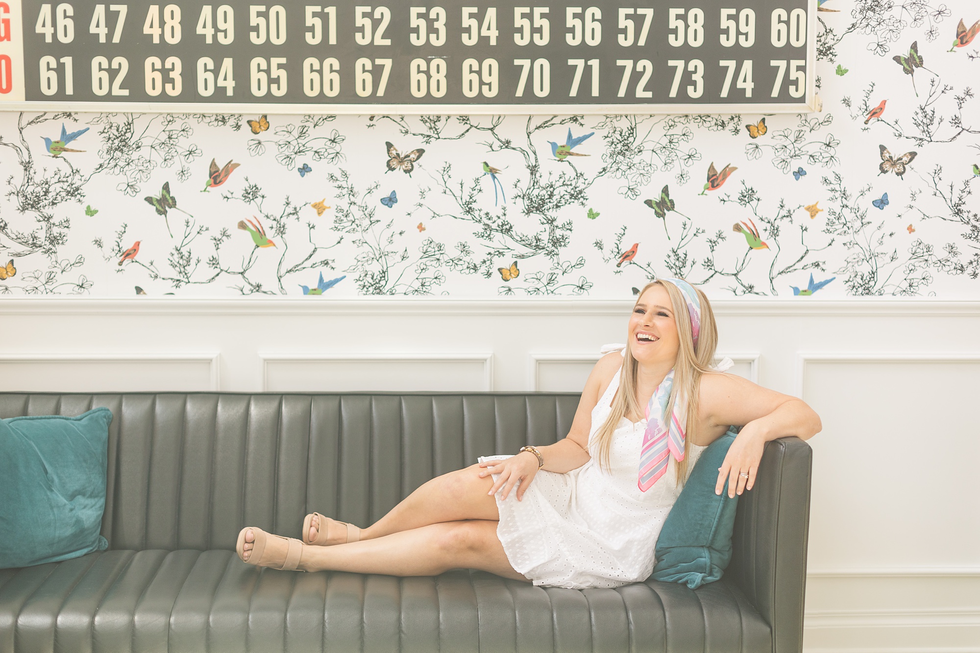 singer laughs on couch at the Graduate Hotel