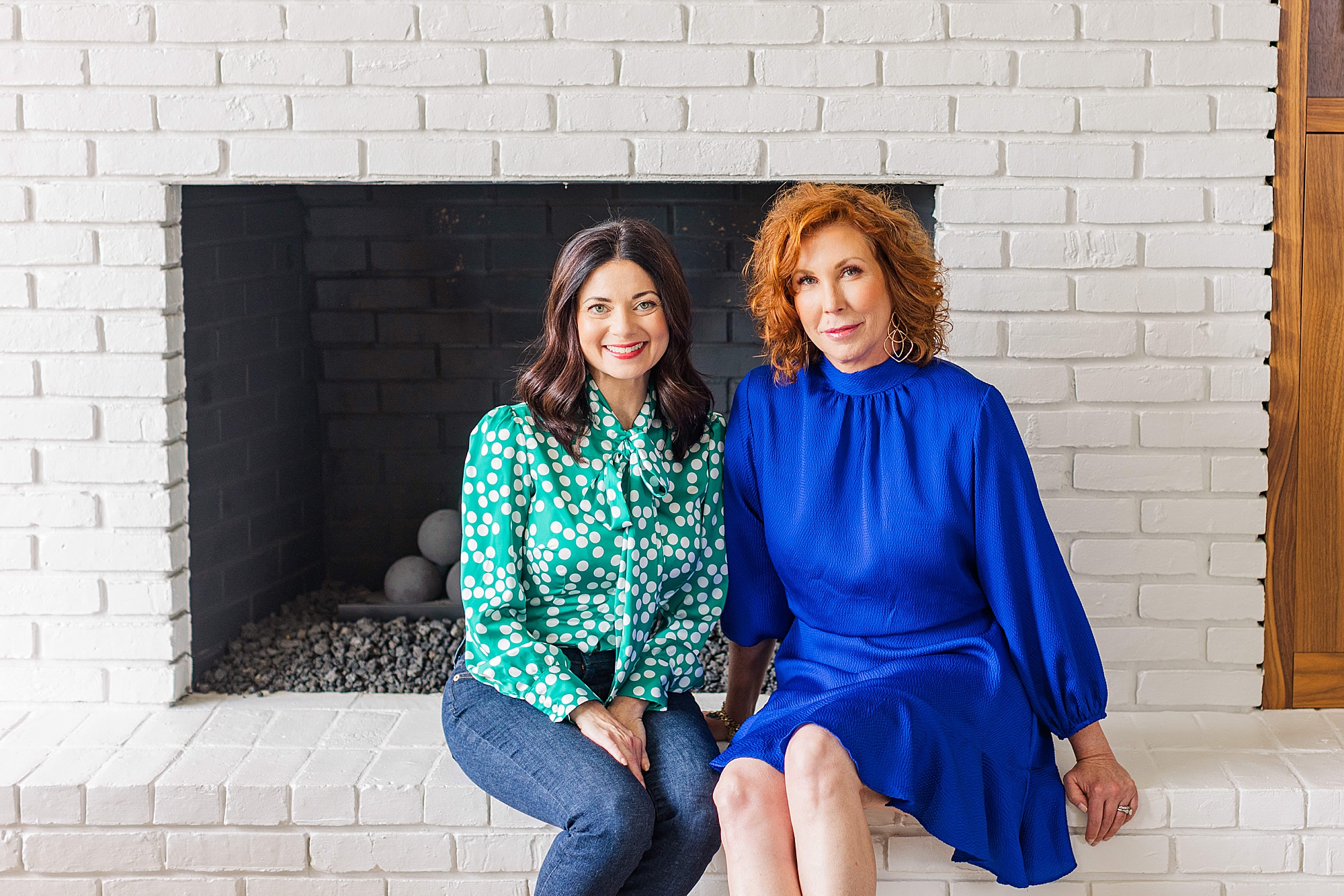women sit on white fireplace during branding session for Nashville podcasters