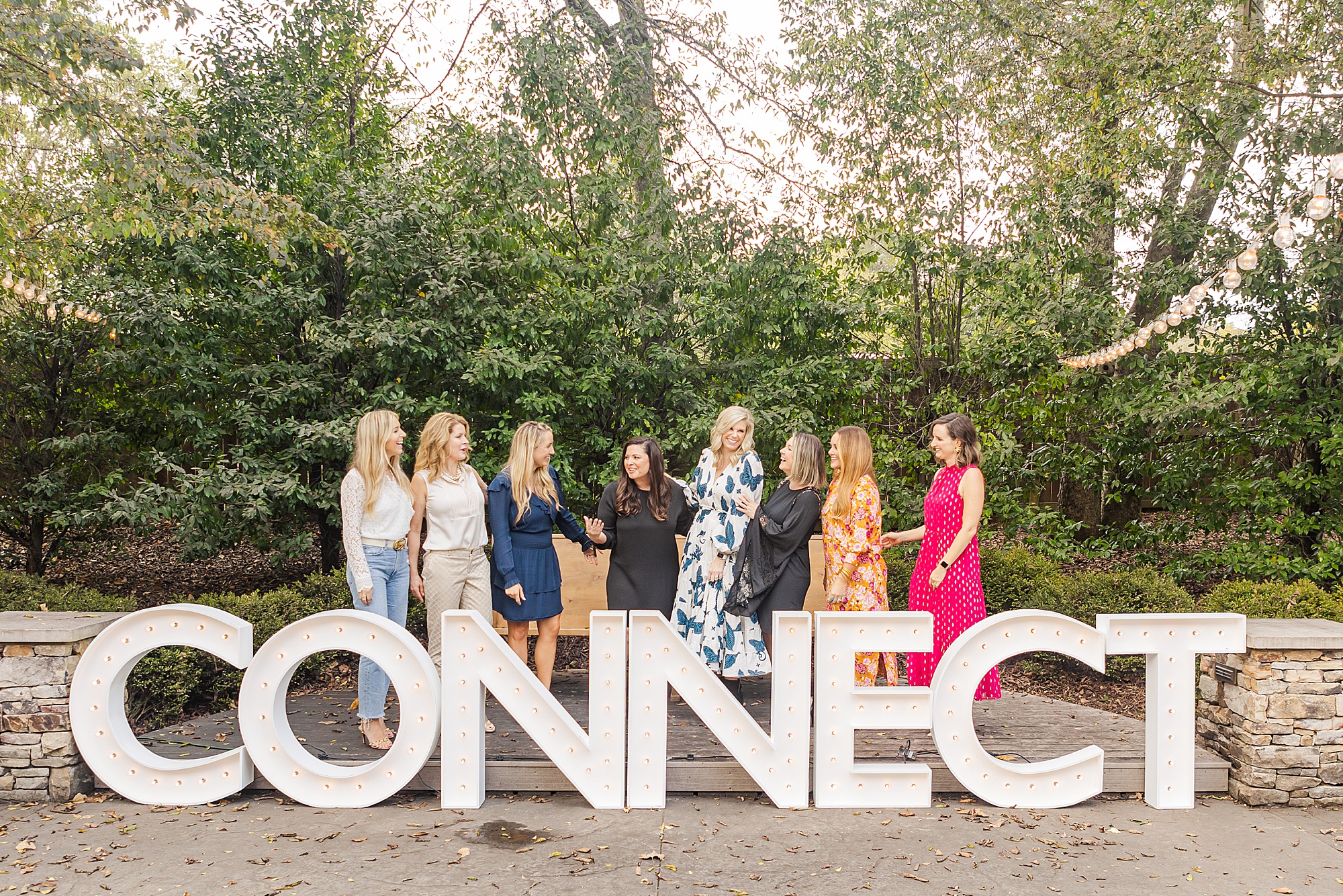women stand together behind CONNECT sign