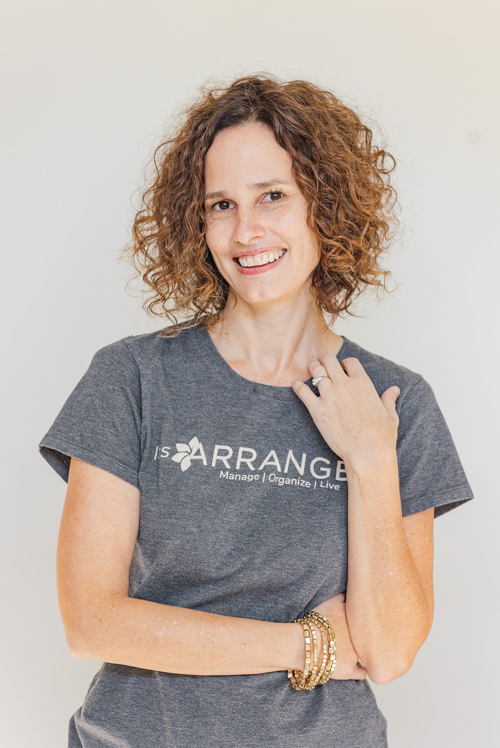 woman poses in company shirt during headshots