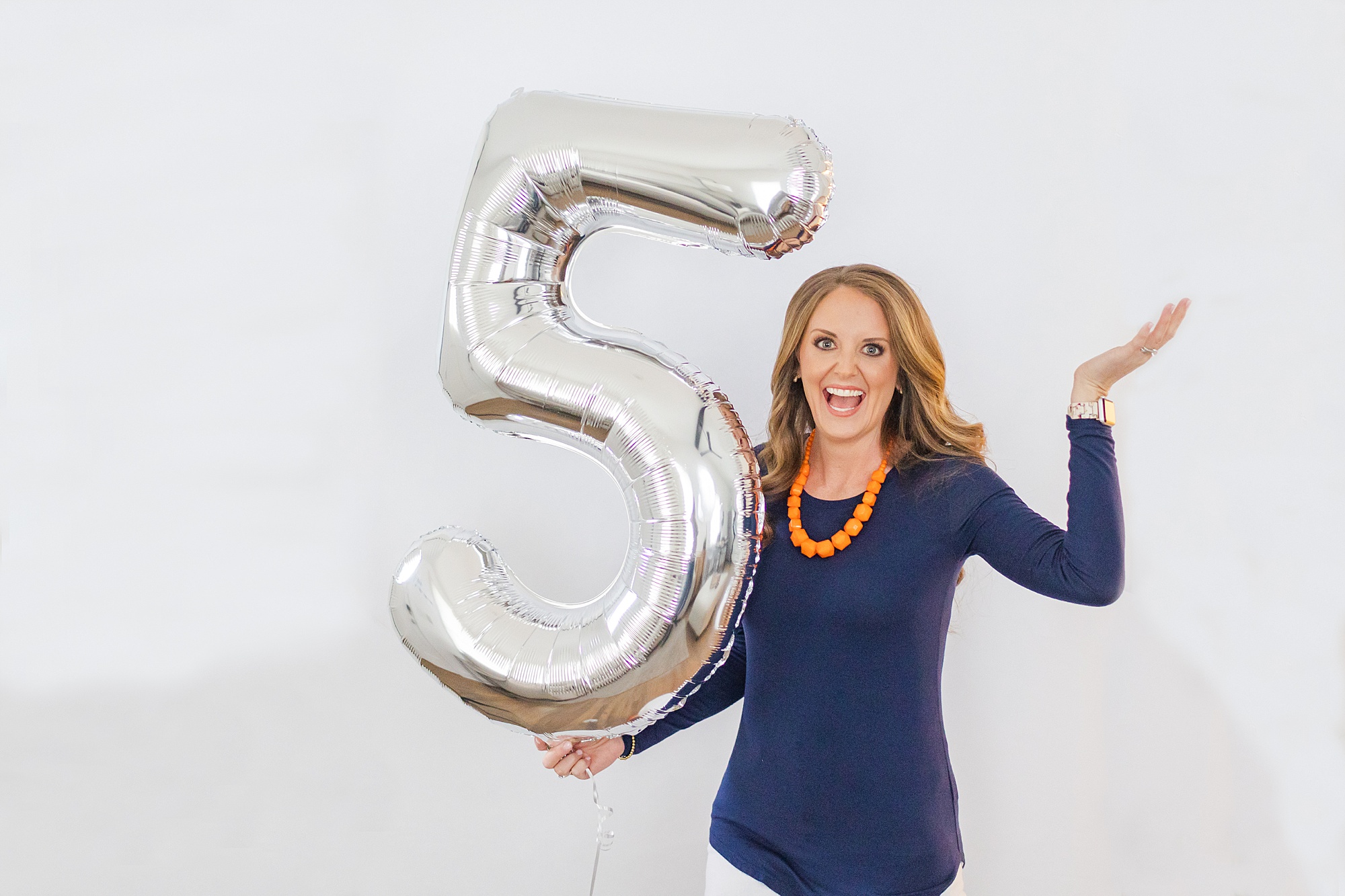 woman holds "5" balloon during branding photos