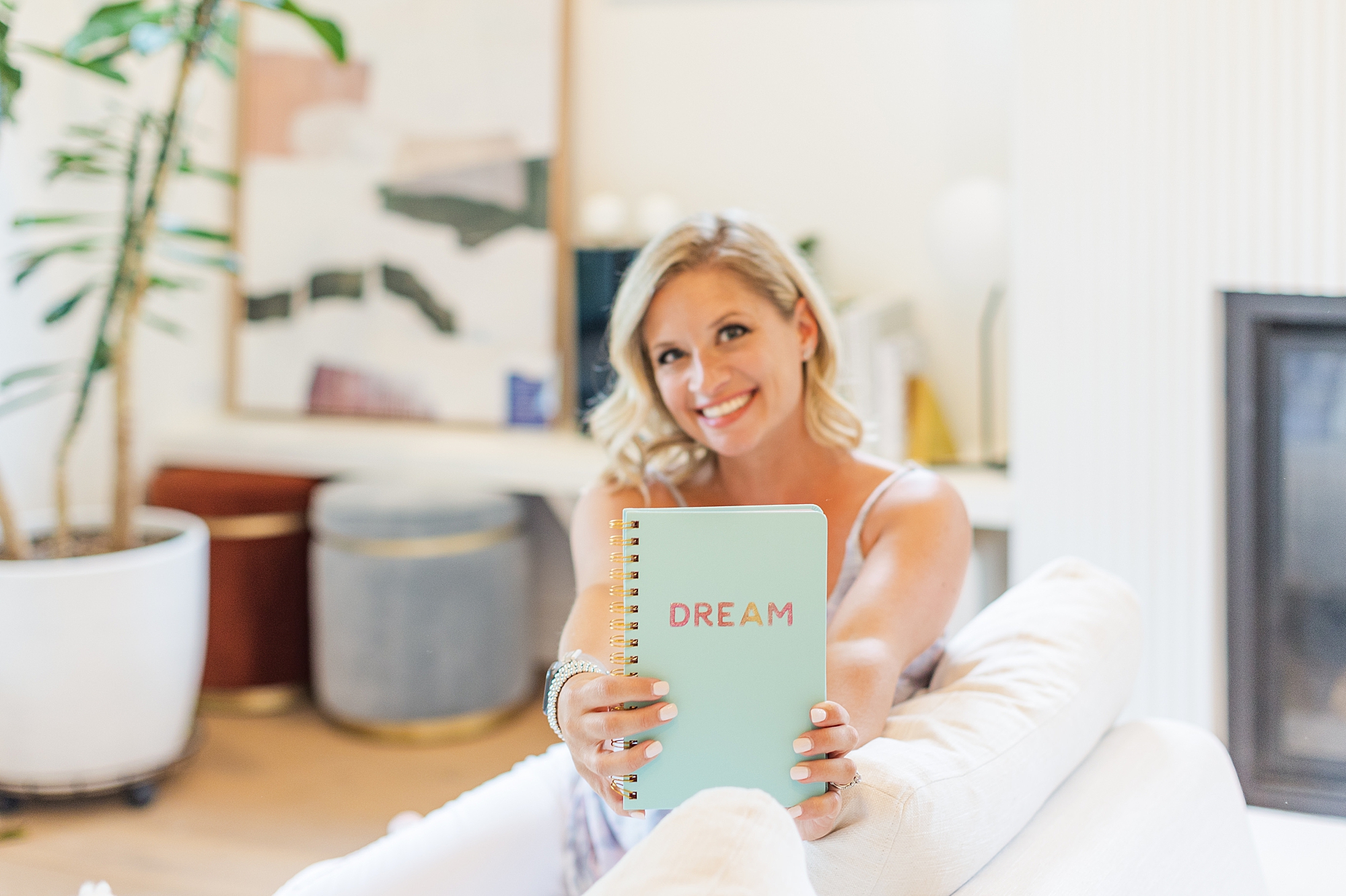 woman holds teal notebook out during branding photo