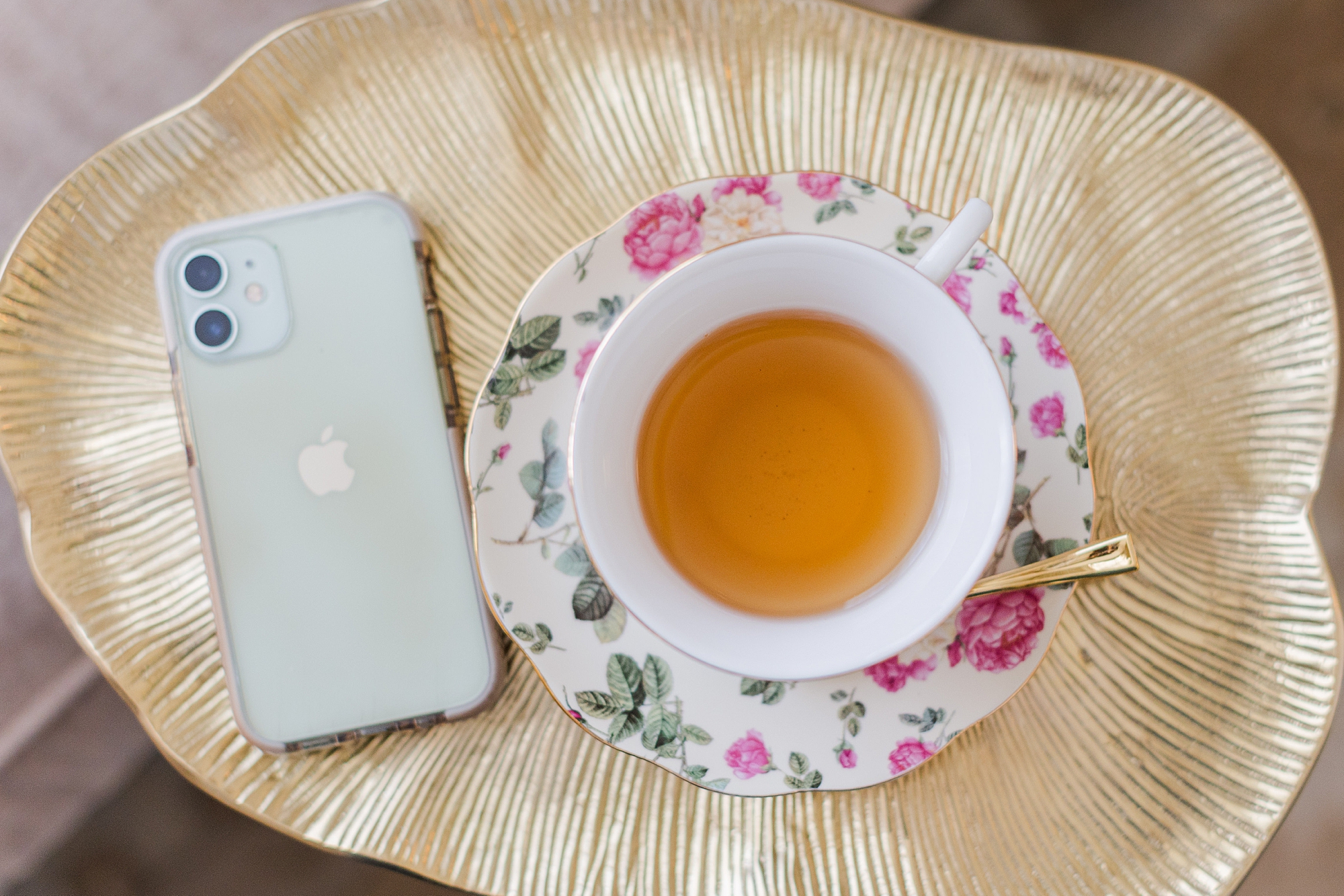 iPhone and cup of tea sit together on wicker basket