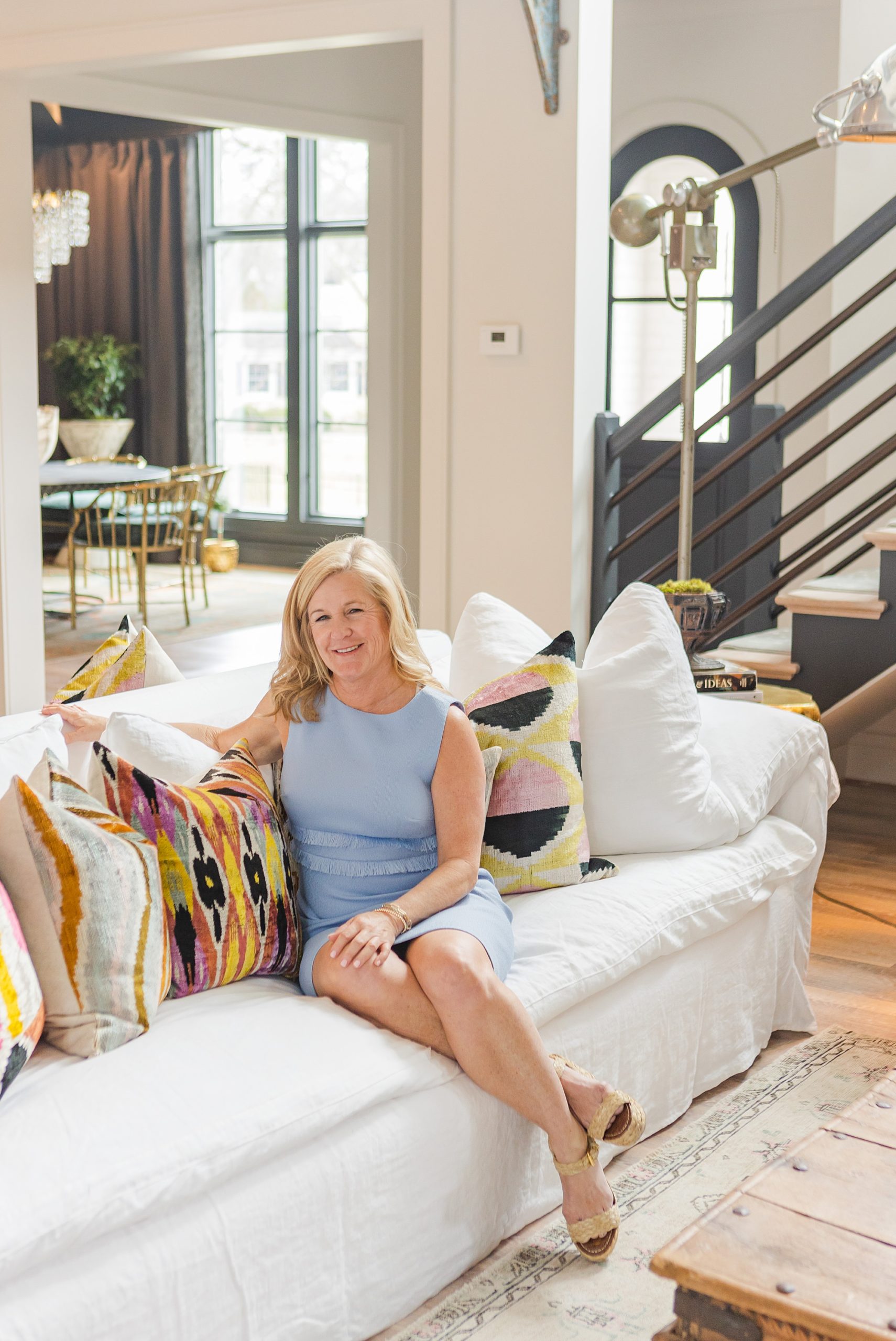 real estate agent sits on white couch at home during Bellevue TN branding session