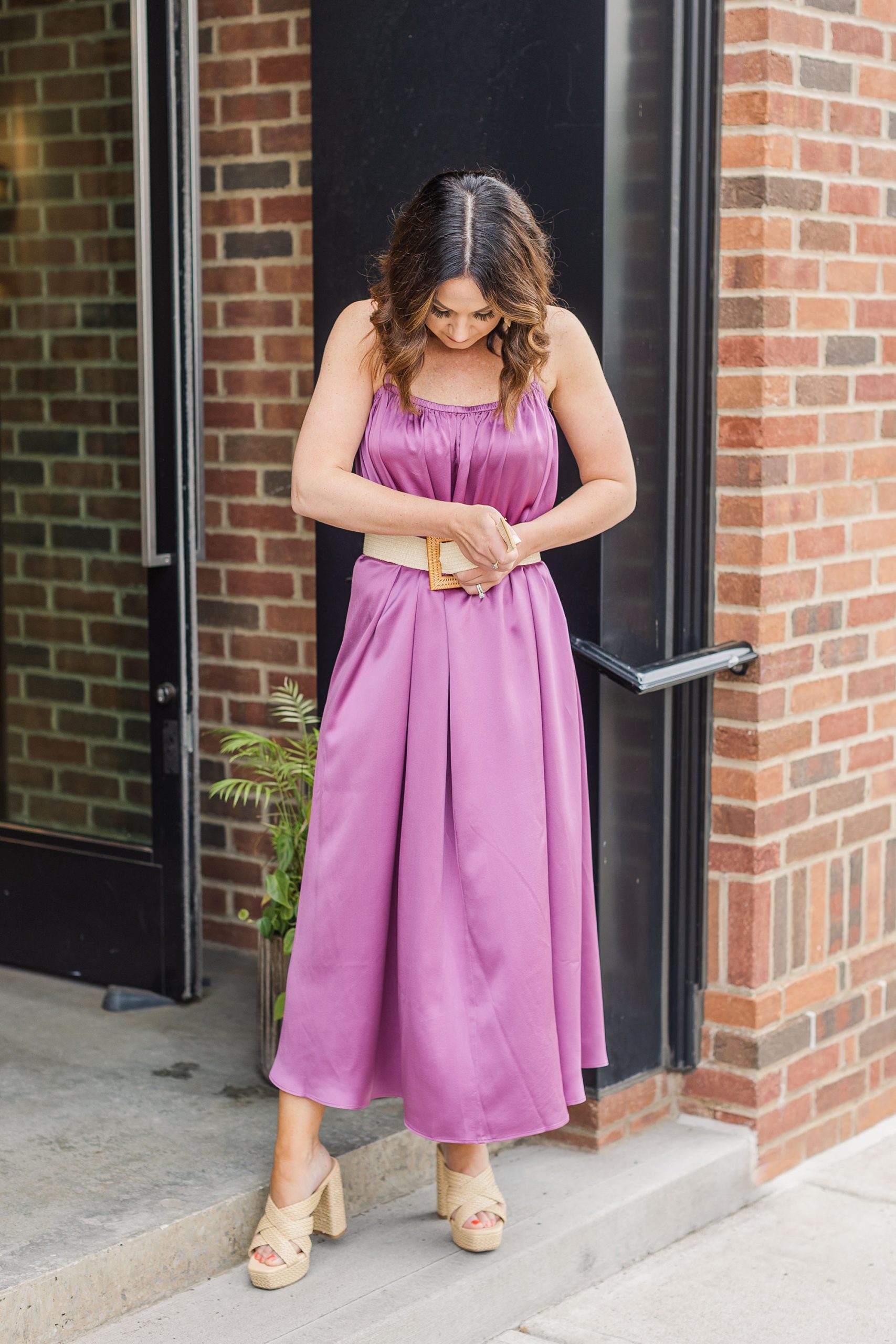 woman adjusts belt on pink silk dress in Franklin TN