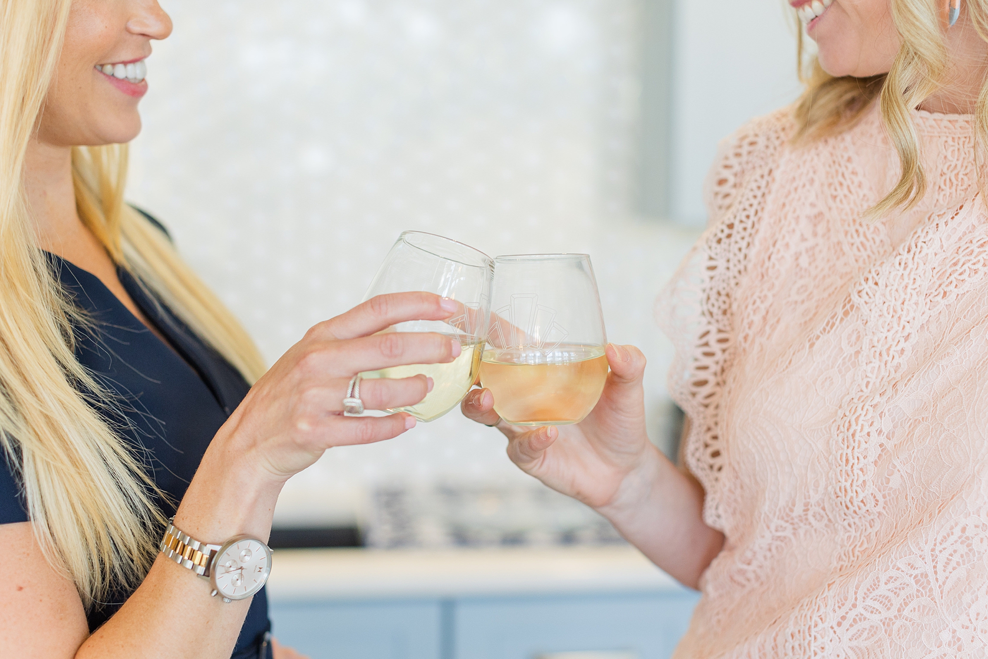 women clink wine glasses during branding photos at The Sapphire Suite