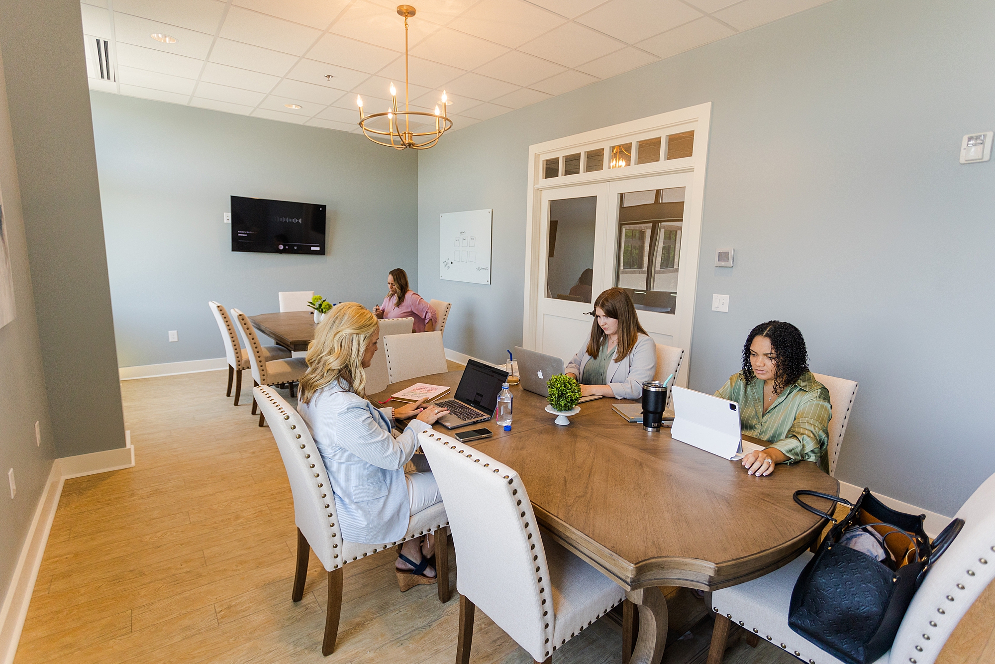 women sit around table working at luxury co-working space at The Sapphire Suite