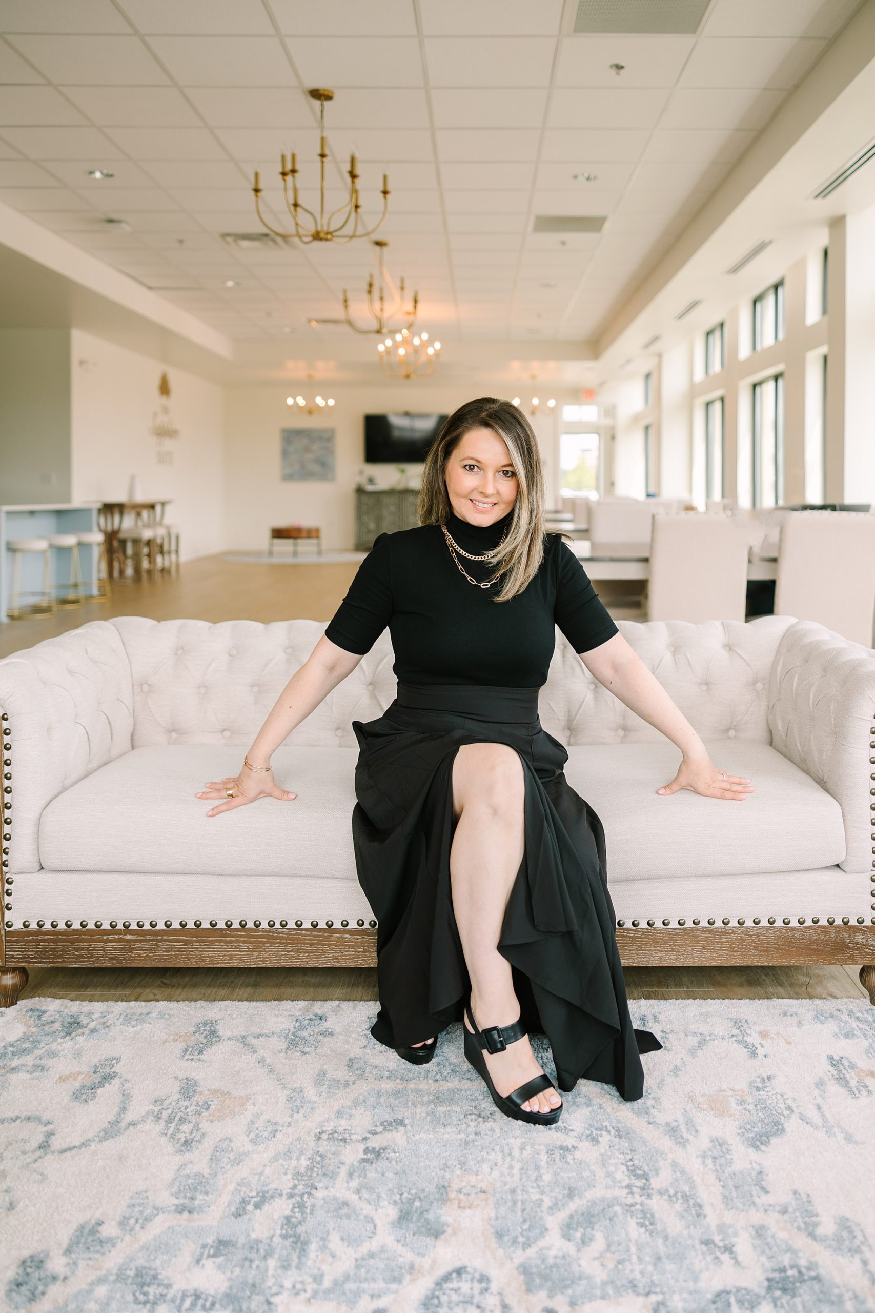 woman sits on couch during Sapphire Suite branding session