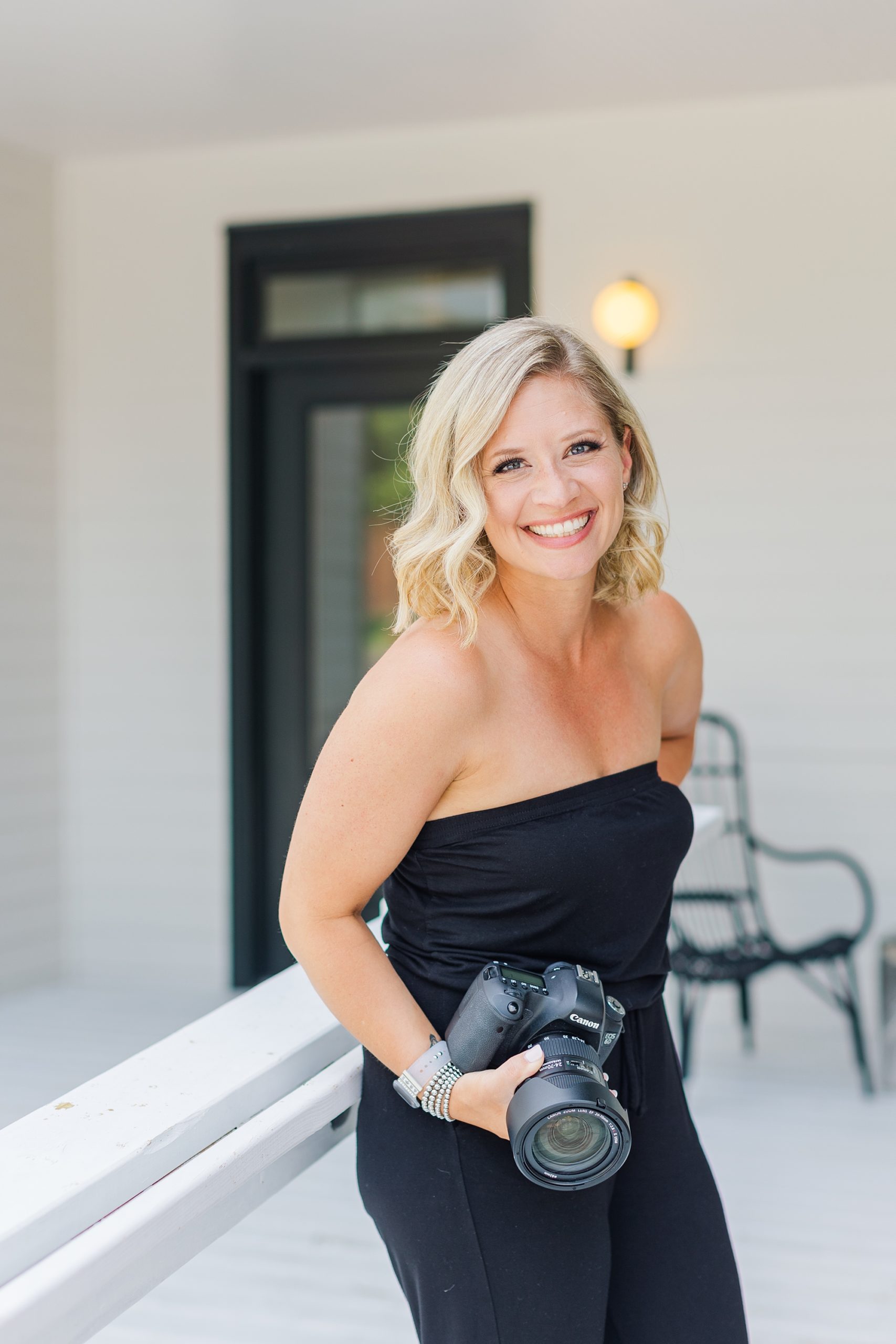 woman stands on porch holding camera against hip during TN branding photos
