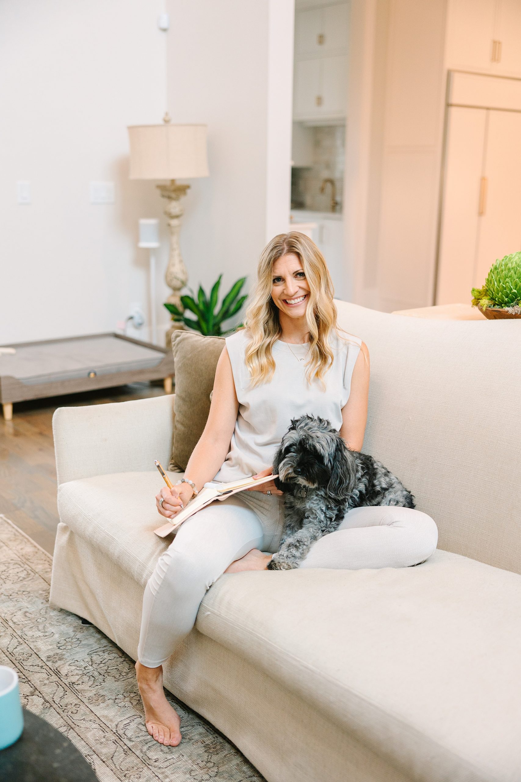 health coach works on couch at home with dog