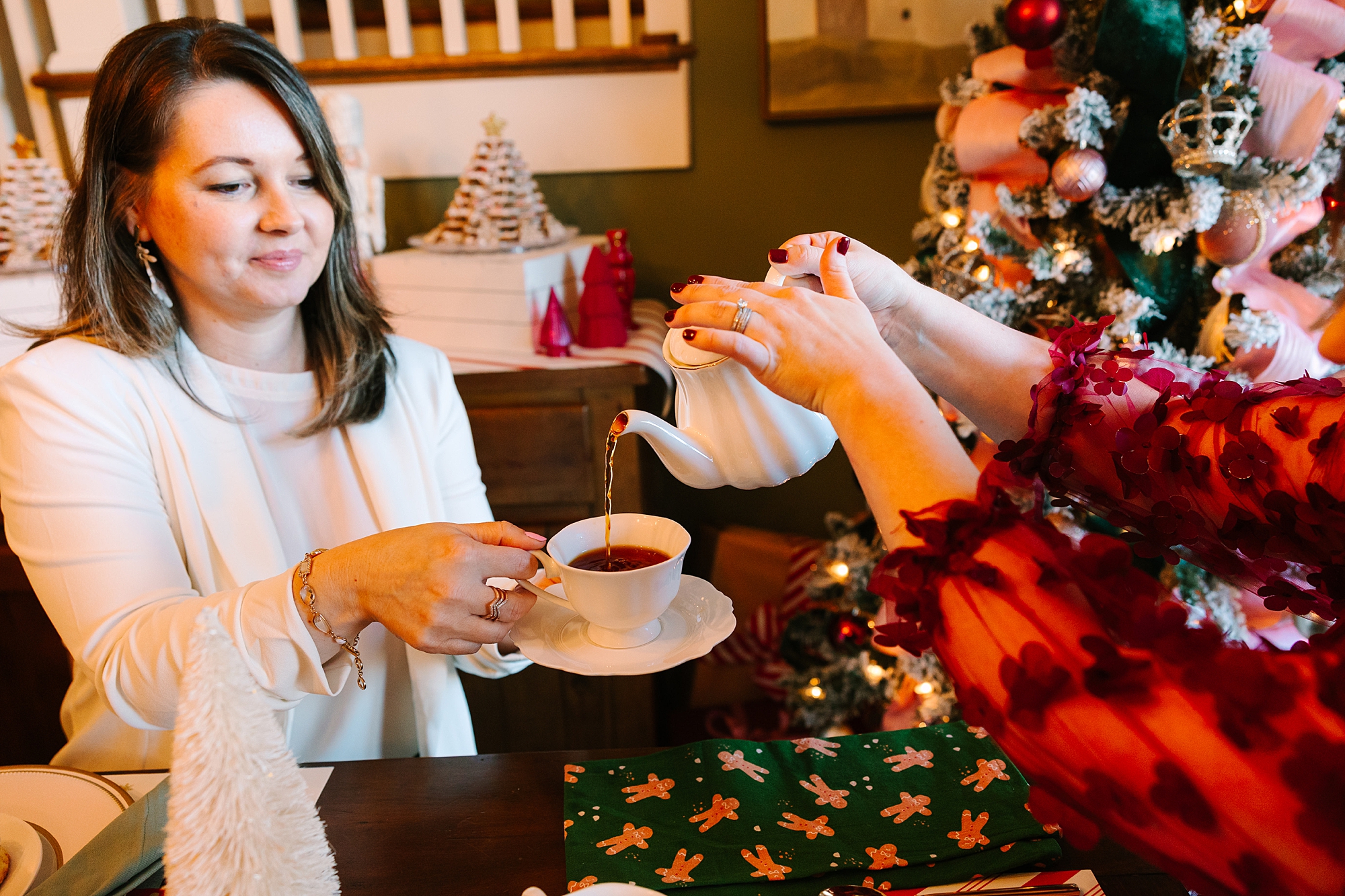 business owner pours tea for Christmas tea party