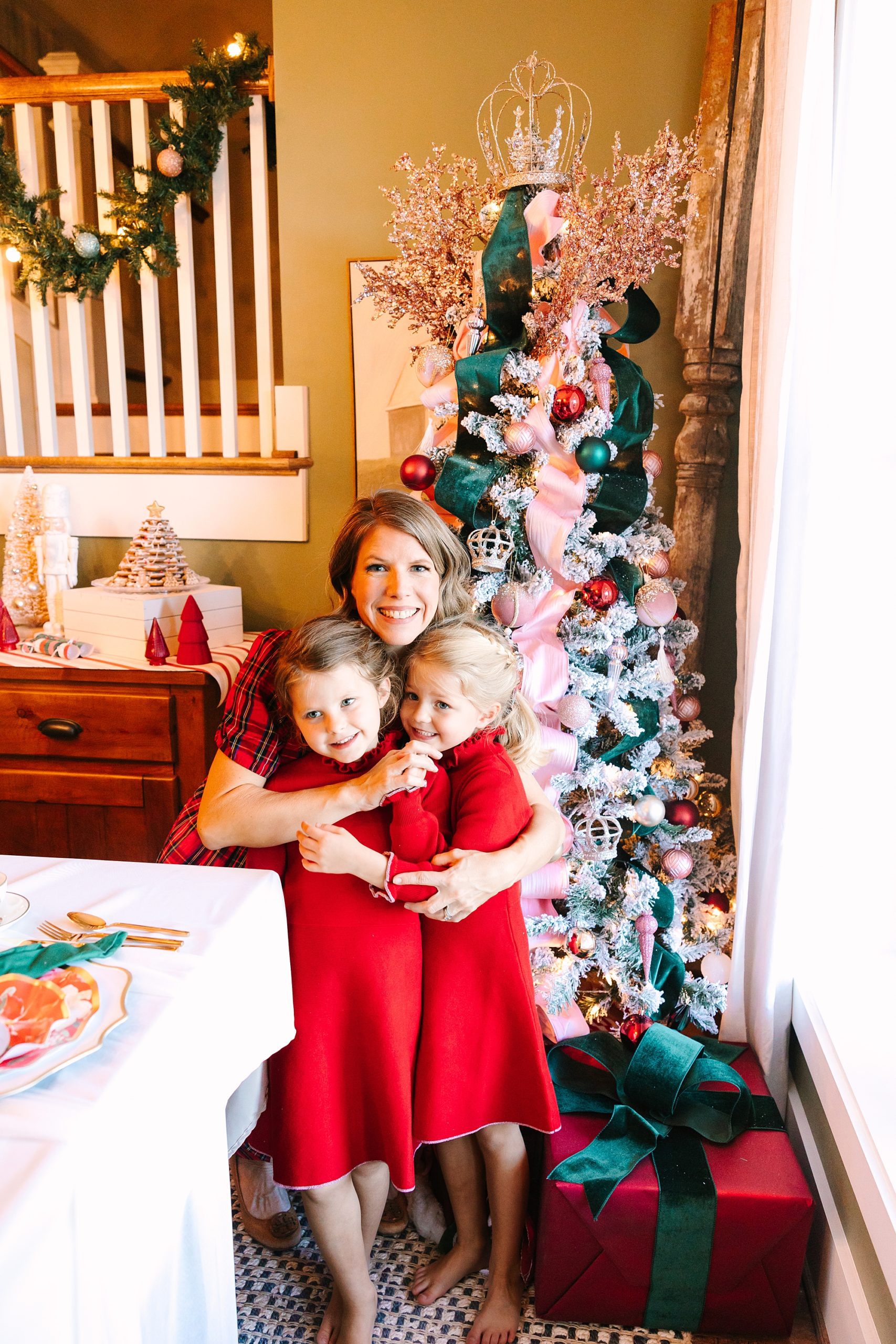 mom hugs daughters in red dresses during Nutcracker inspired tea party with Pretty Lovely Tea