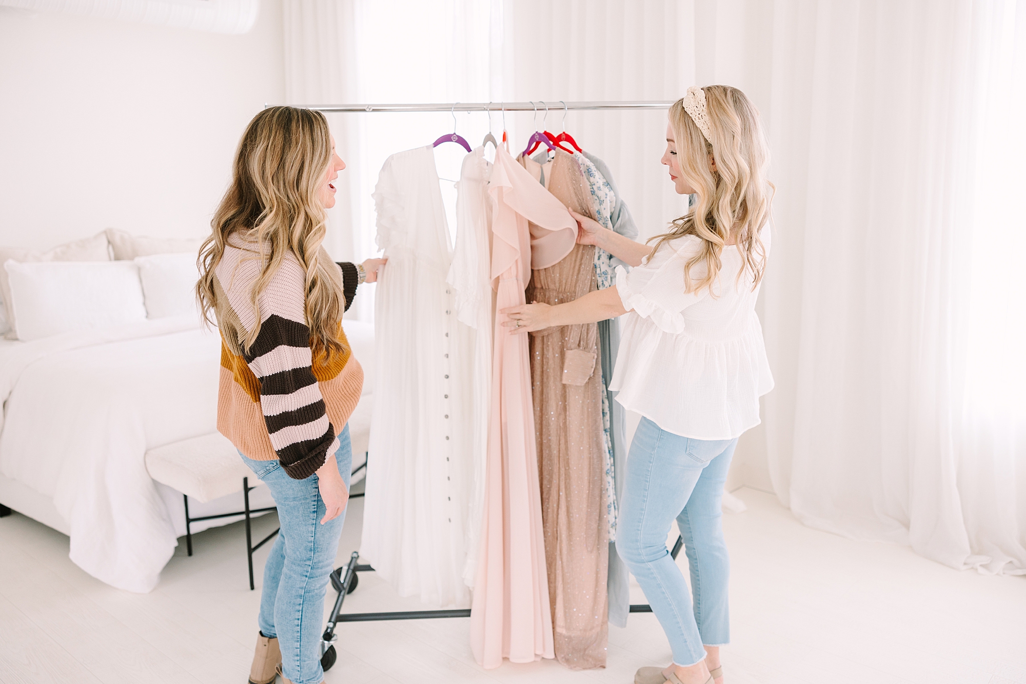 photographer helps mother choose outfit from rack at Studio Blanc in Nashville, TN
