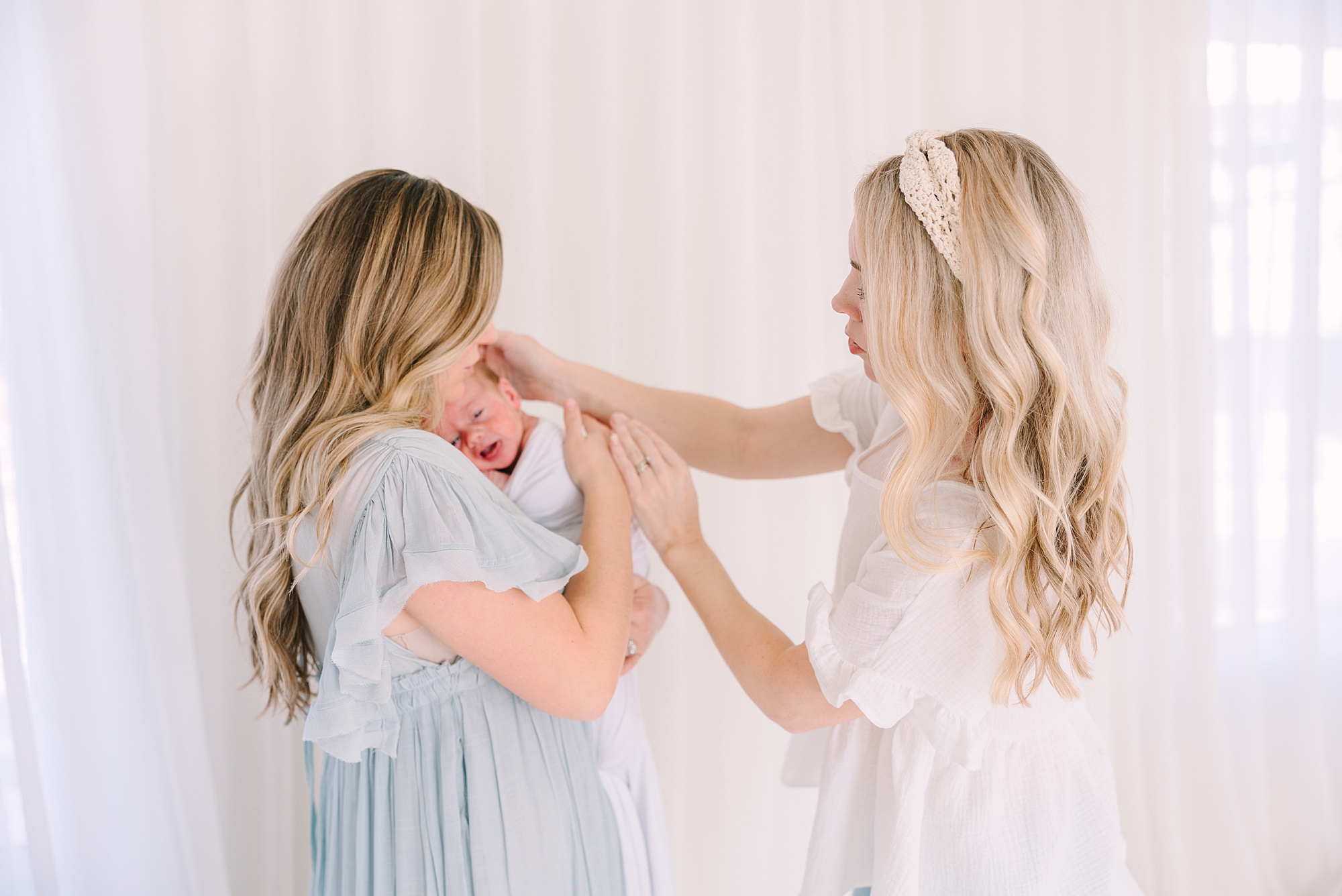 mother in blue dress holds newborn baby during photo session at Studio Blanc in Nashville, TN