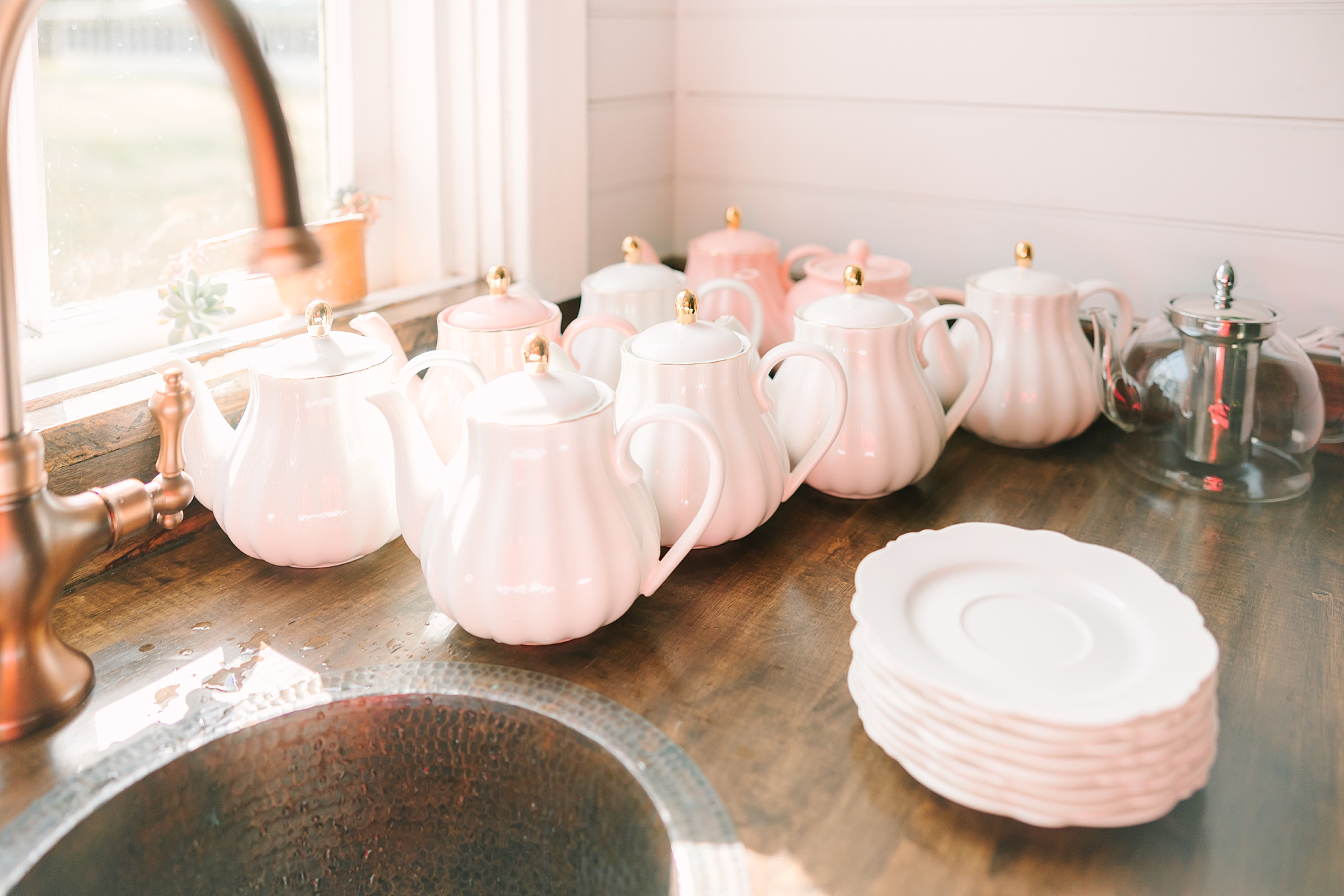 white teapots lined up by white plates for Galentine's Day Tea Party
