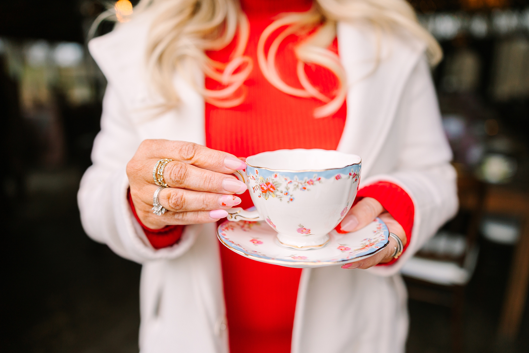 woman in red jacket holds tea cup