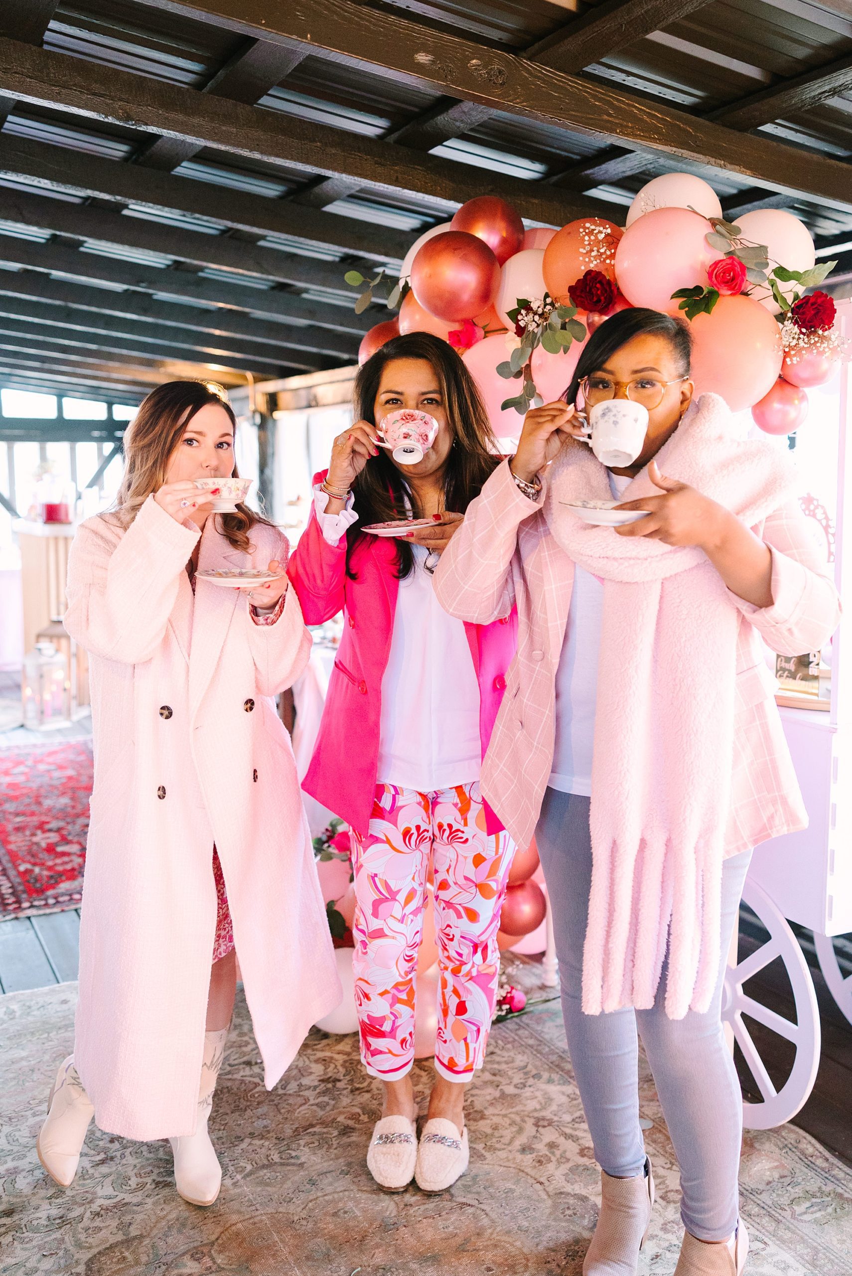 women in pink outfits drink out of tea cups at Galentine's Day Tea Party