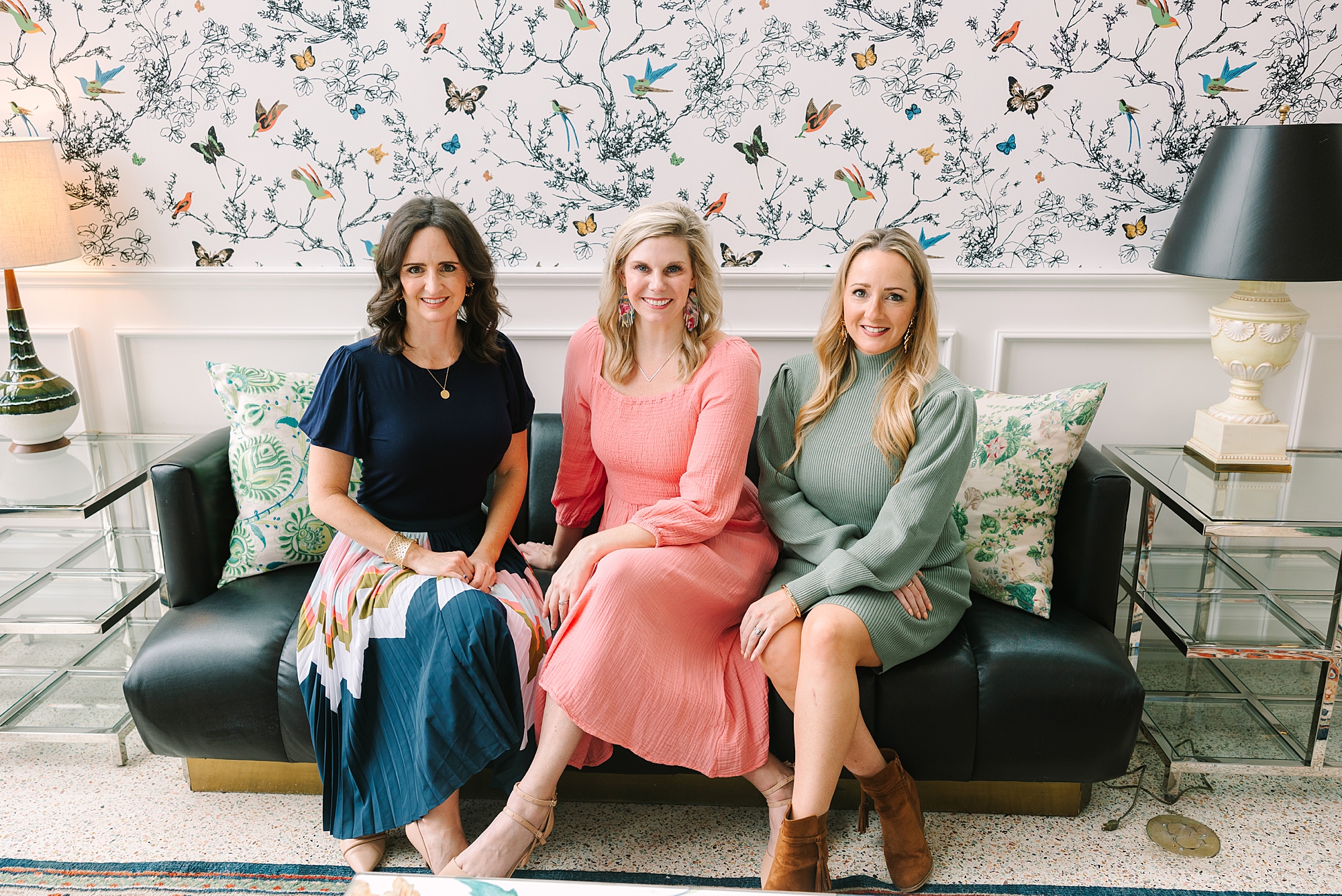 three women sit on sage green couch at The Graduate Hotel Nashville