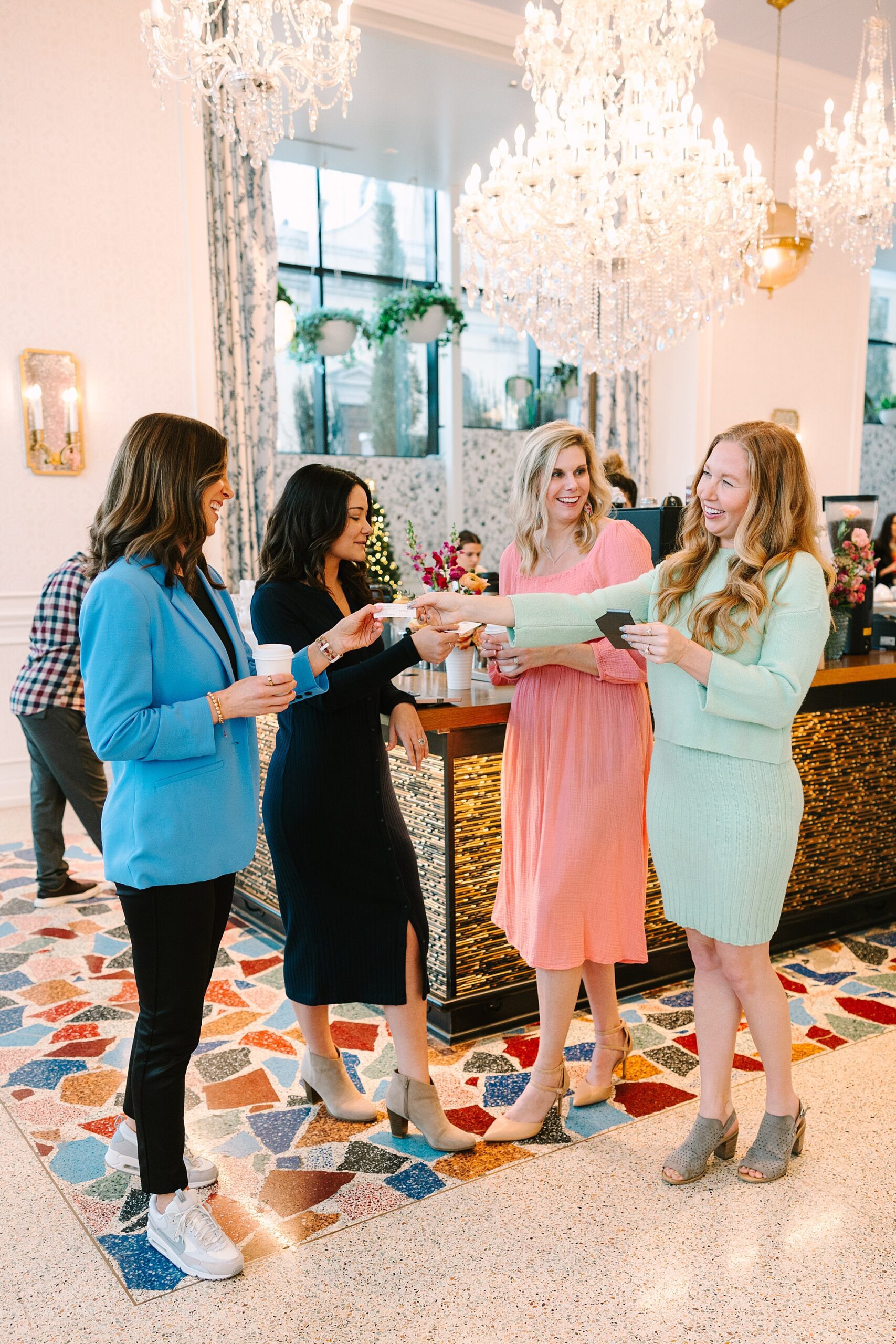 four women talk and exchange business cards during networking event