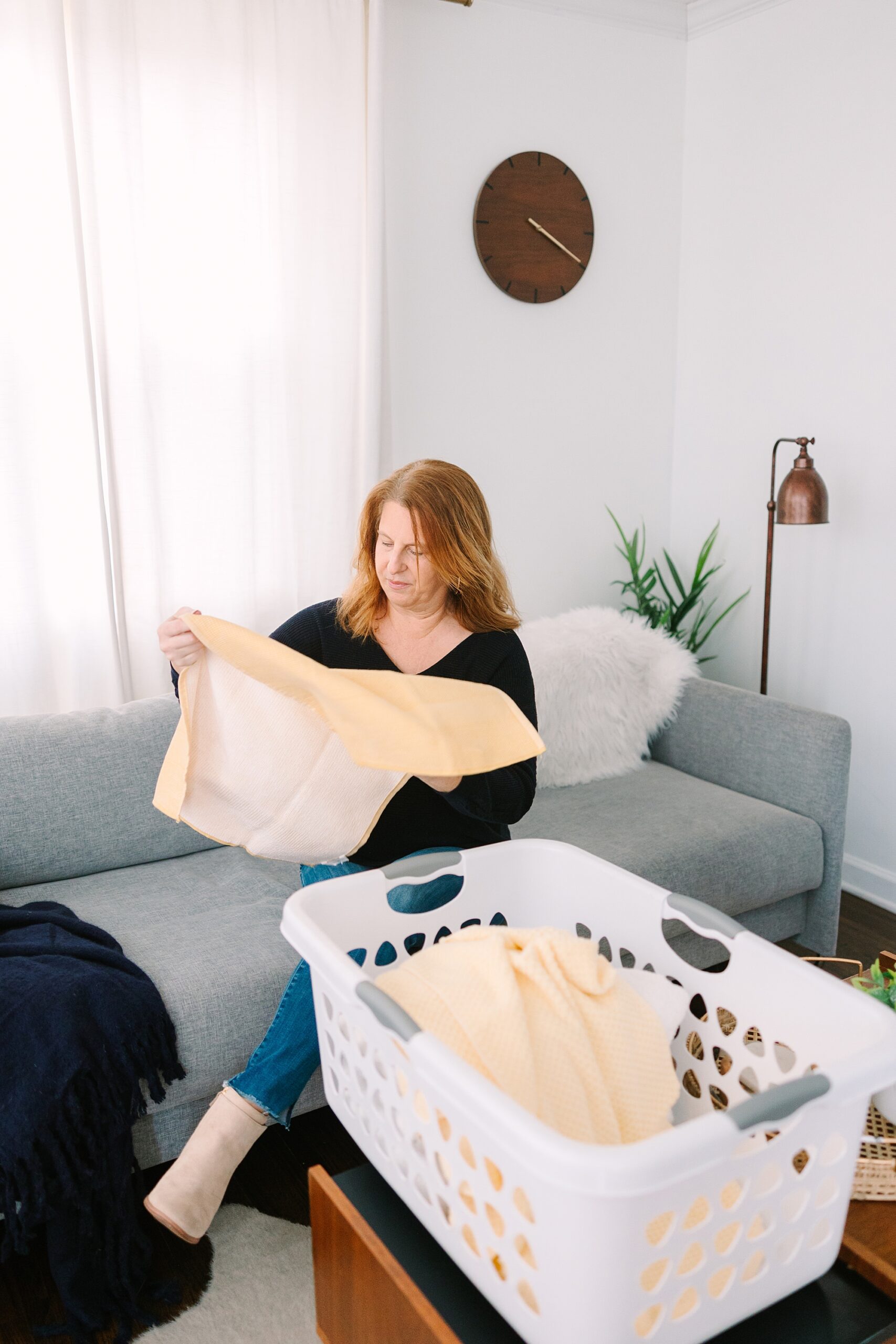 woman folds towels during branding photos