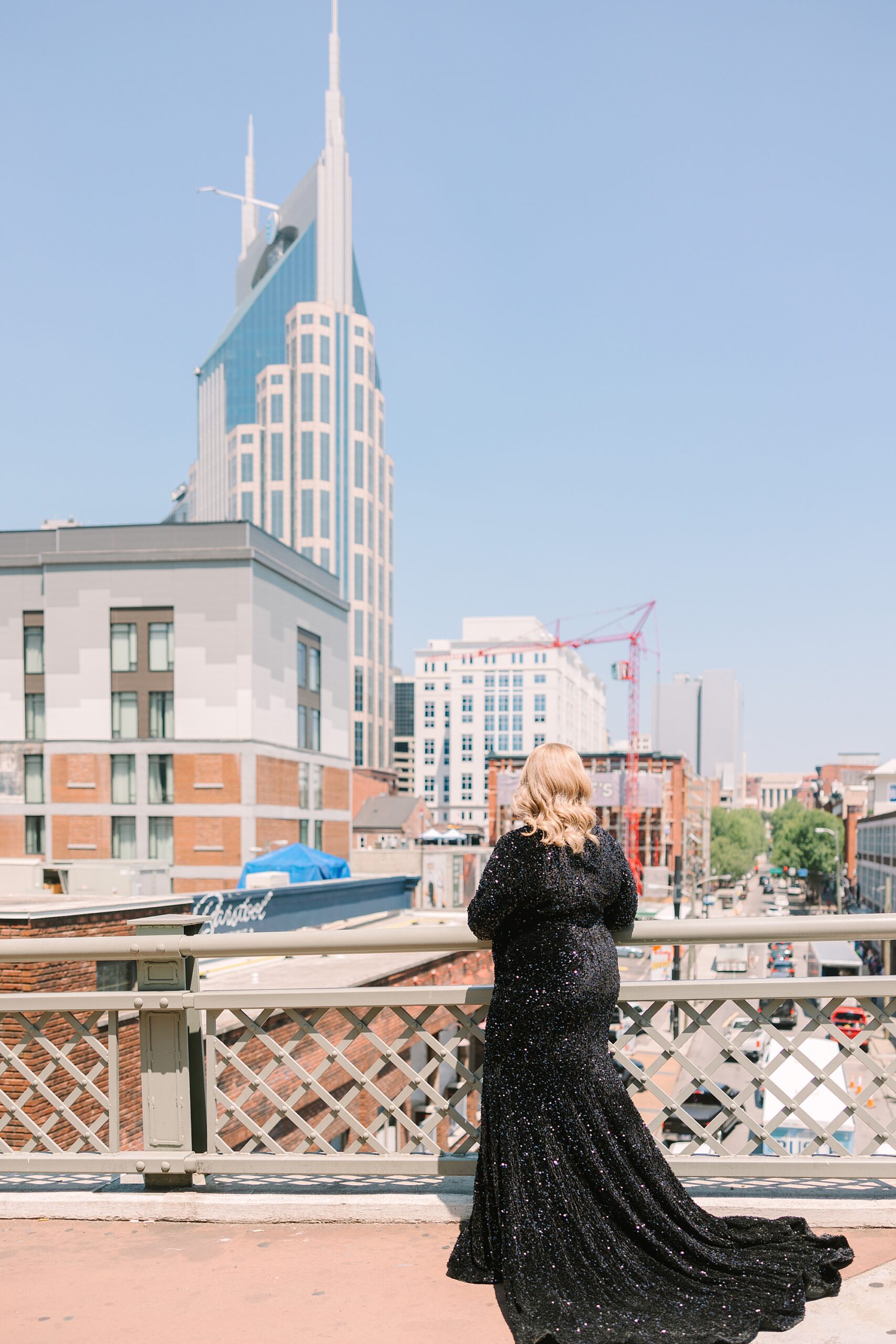 woman looks at downtown Nashville from the pedestrian bridge