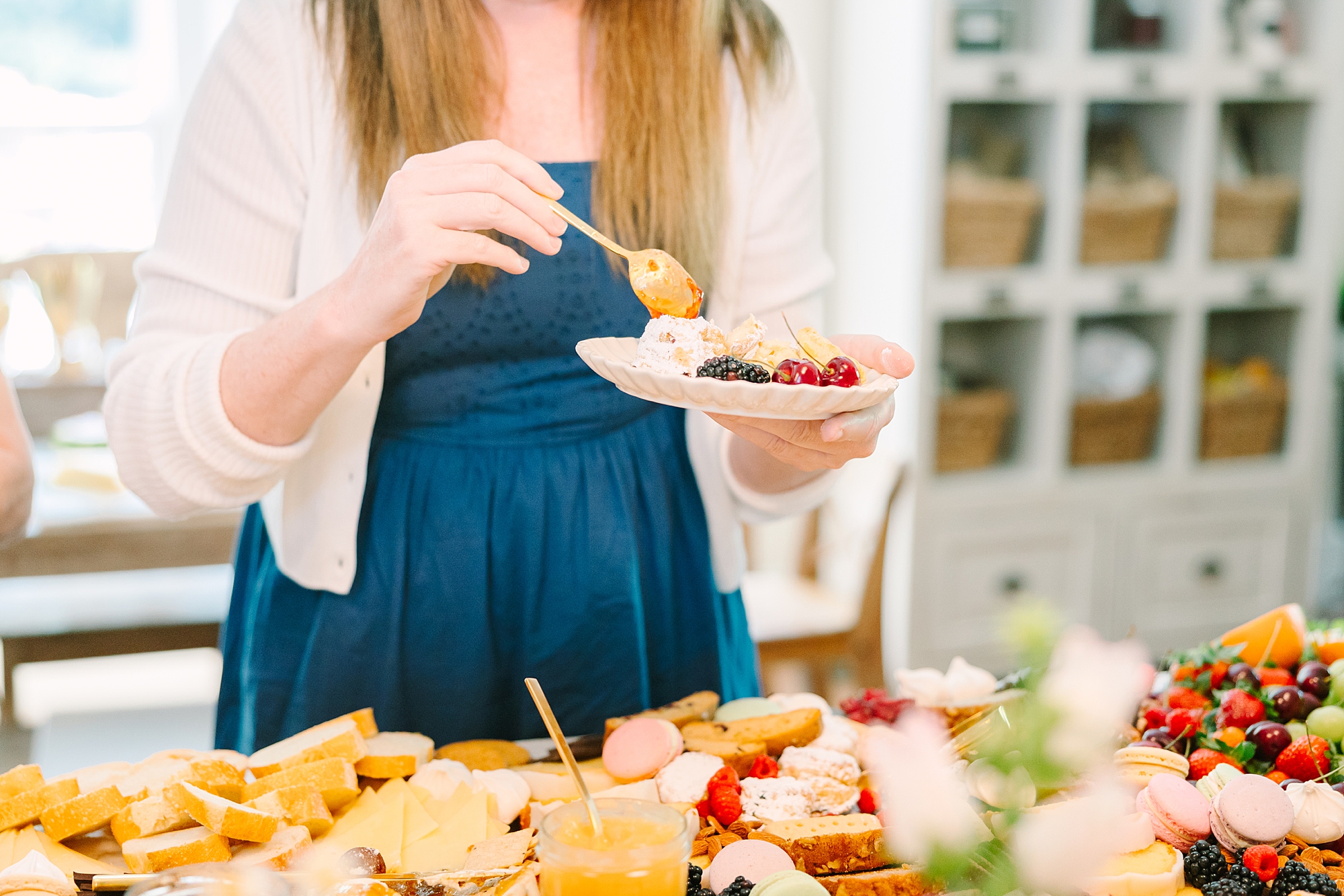 woman fills plate from Pretty Lovely Teas grazing table