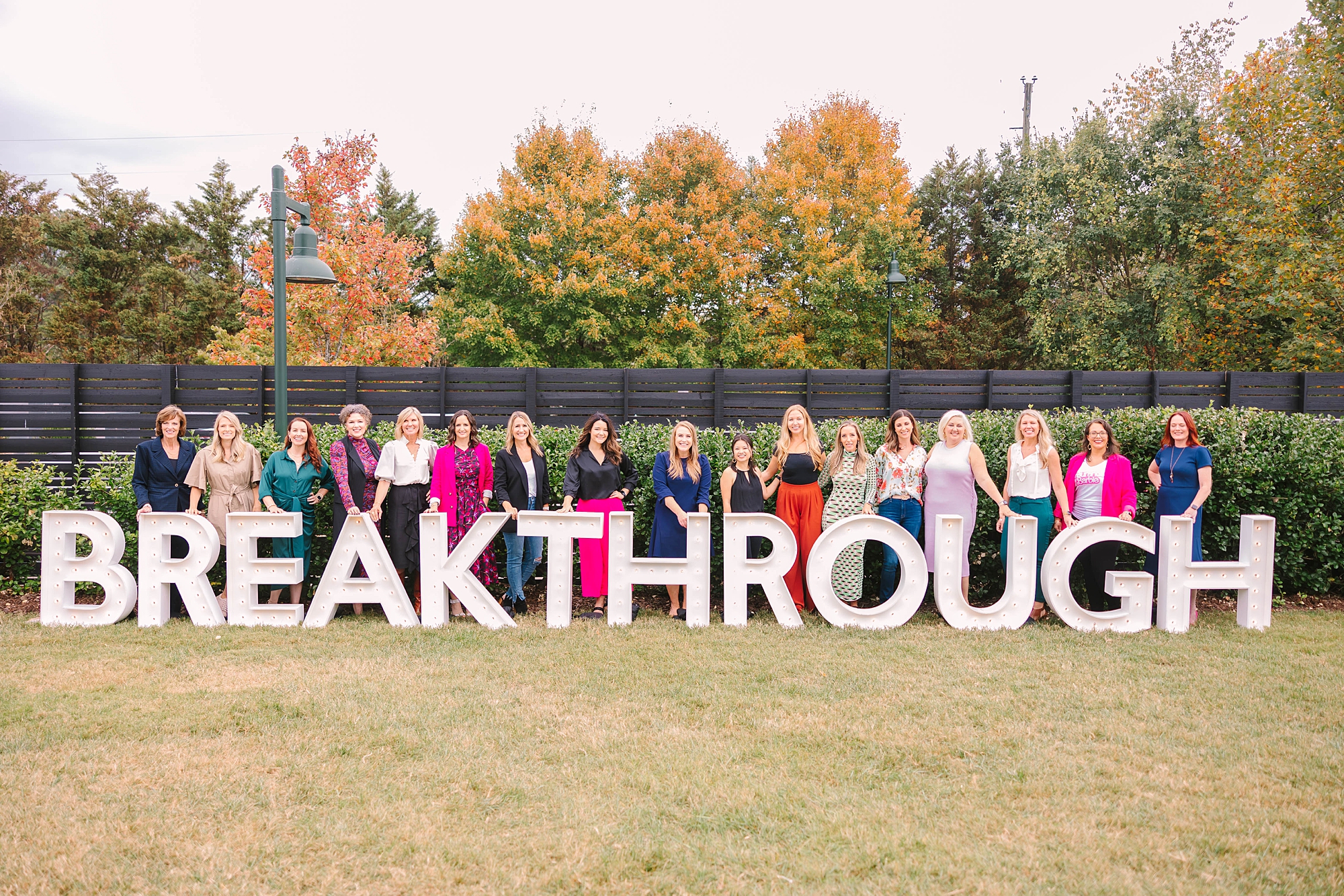 women pose behind "BREAKTHROUGH" sign at Tennessee Women Connect Live Event at Loveless Barn