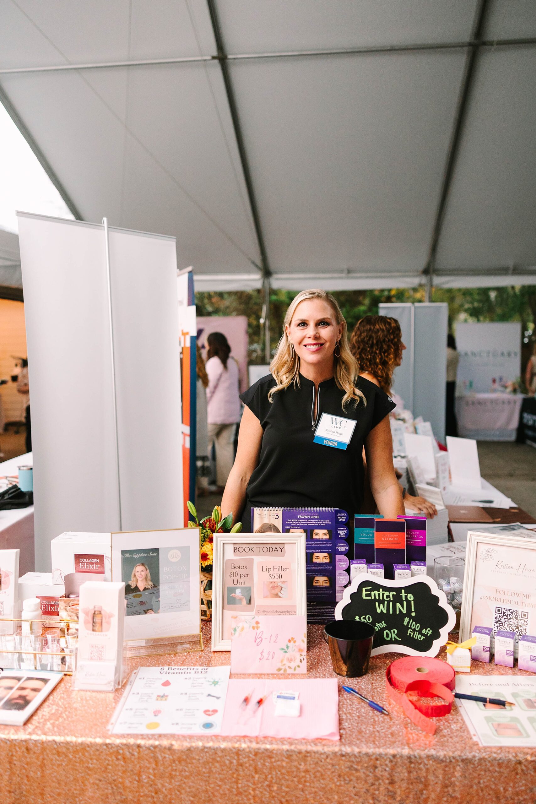 female business owner stands behind display at live event