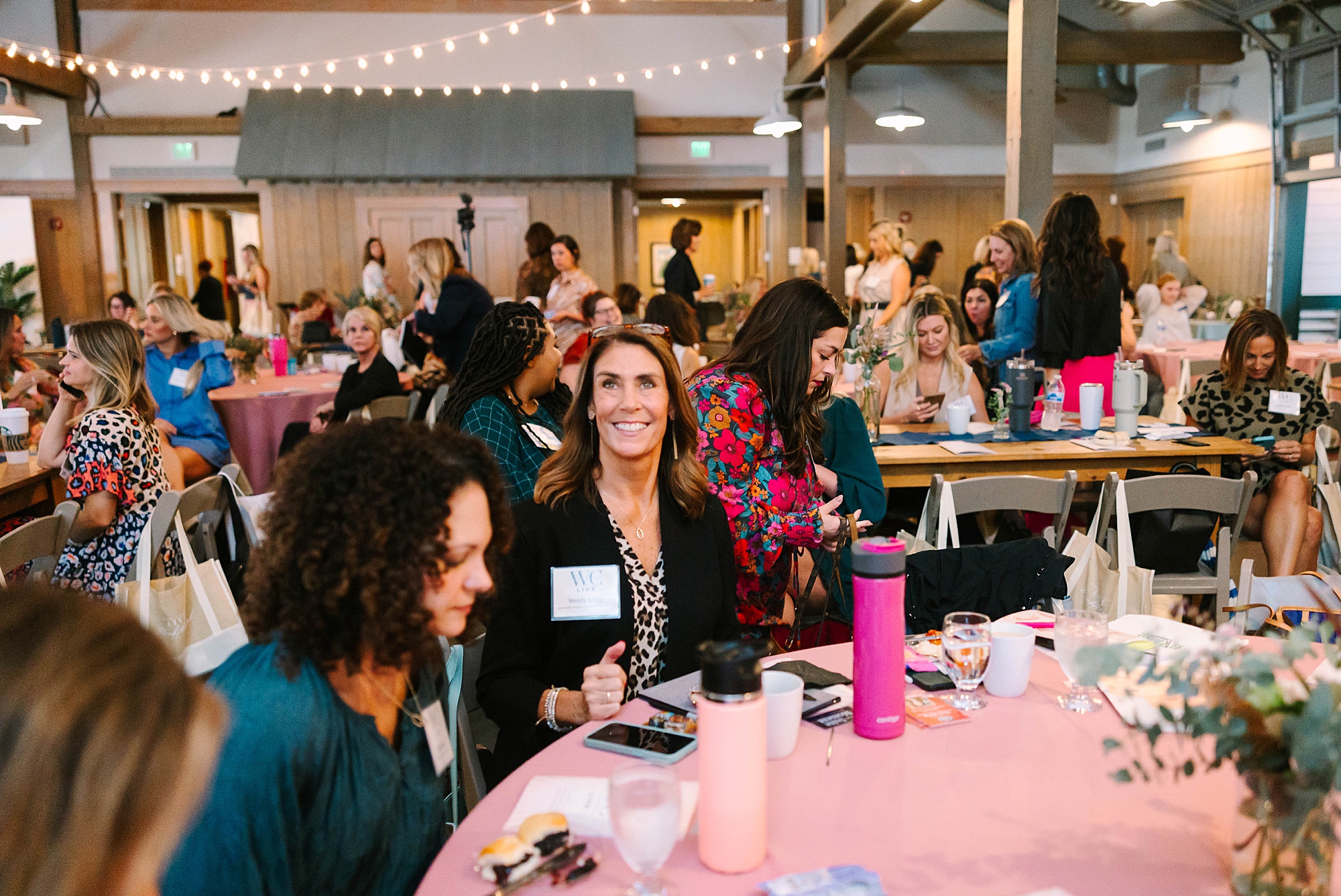 woman smiles sitting at table during event at Loveless Barn