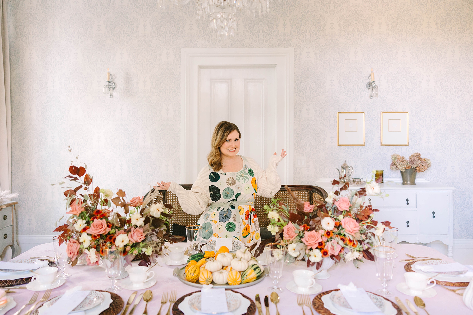 woman stands by table display for fall and Thanksgiving inspired tea by Pretty Lovely Teas