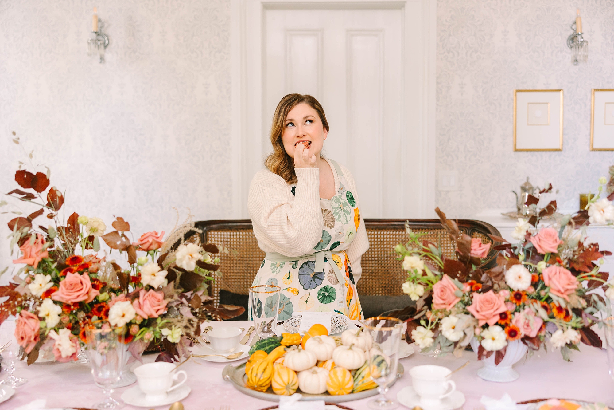 woman laughs eating a treat during setup for fall and Thanksgiving inspired tea by Pretty Lovely Teas