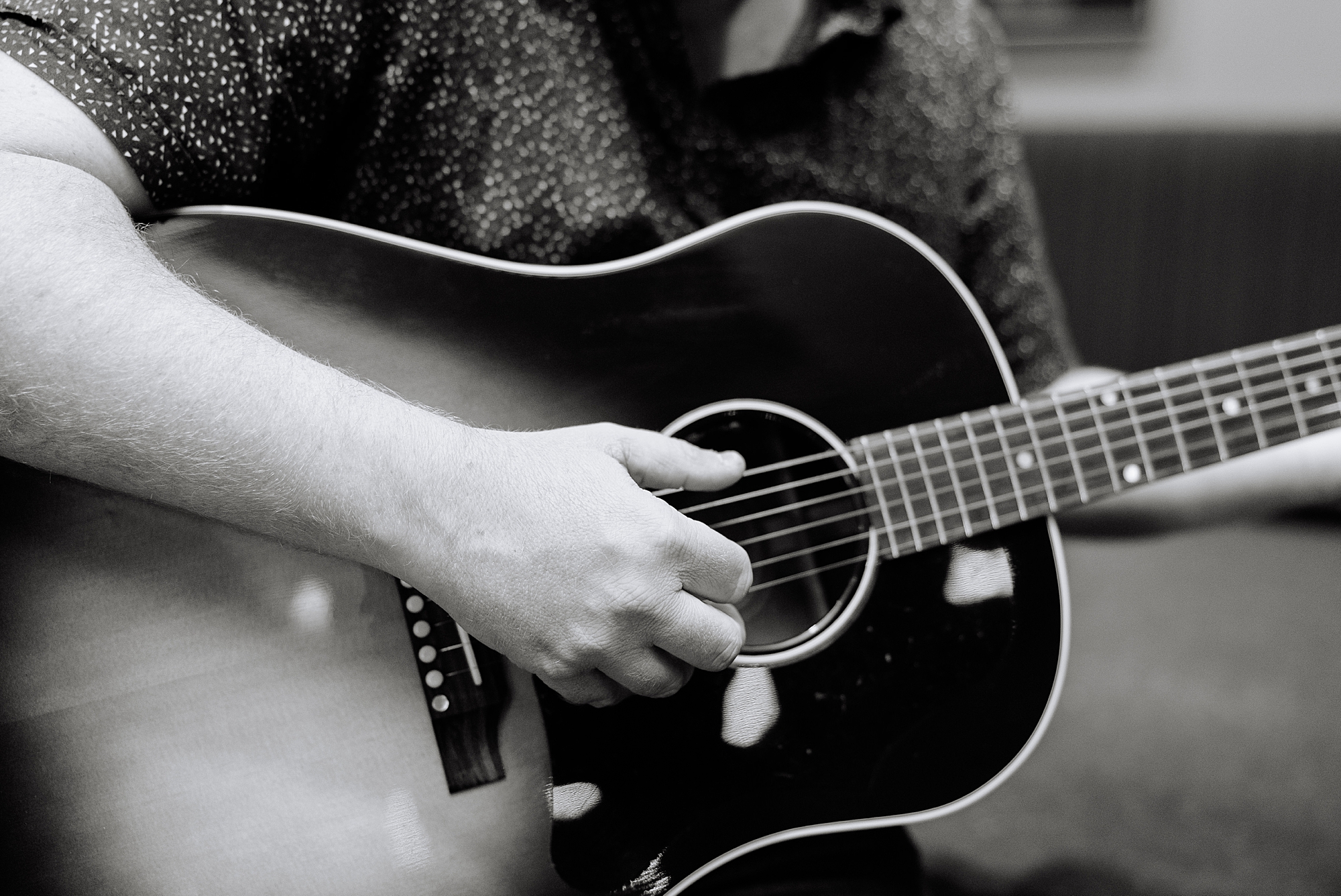 musician strums guitar during Downtown Nashville branding portraits