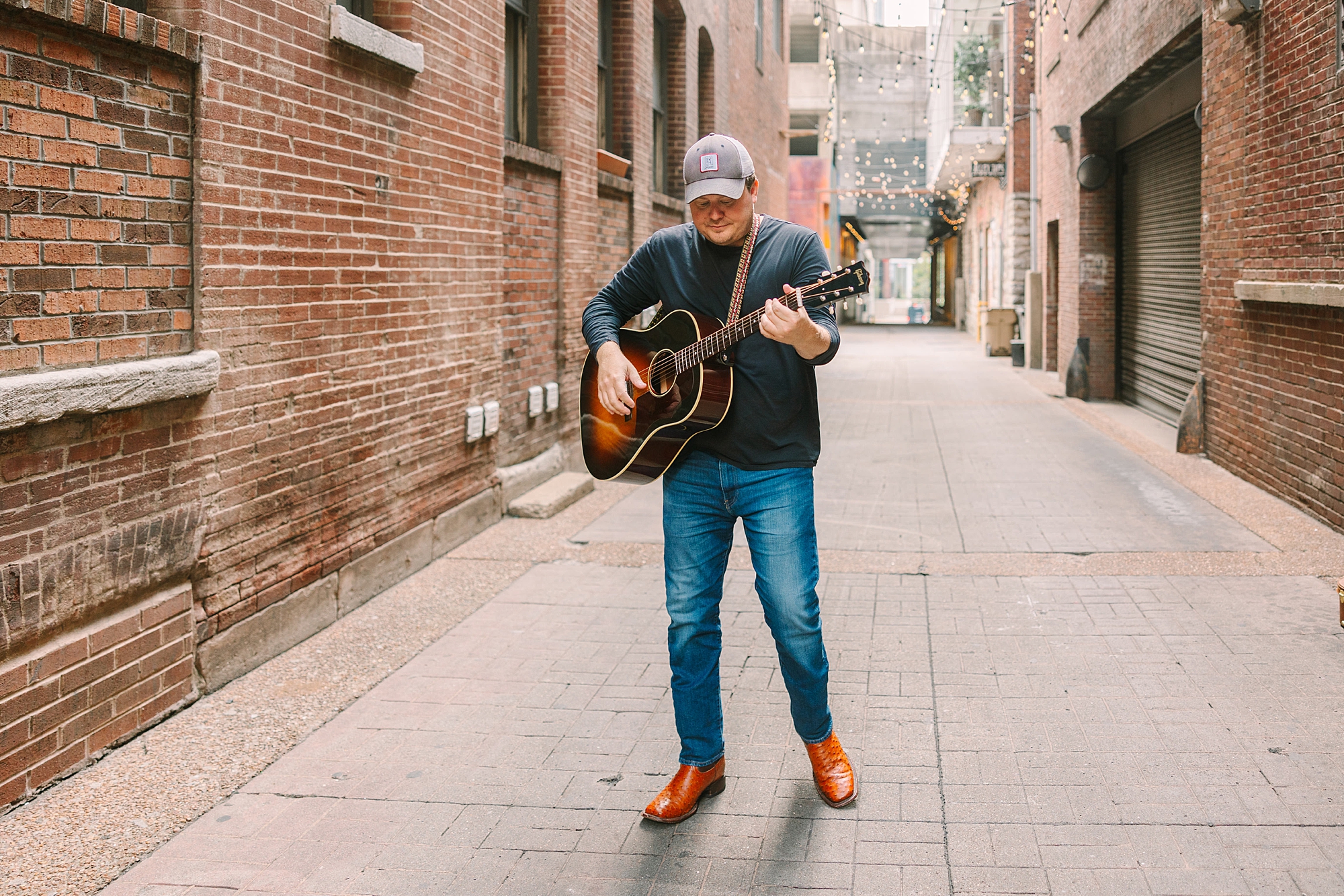 man plays guitar in alleyway of Downtown Nashville
