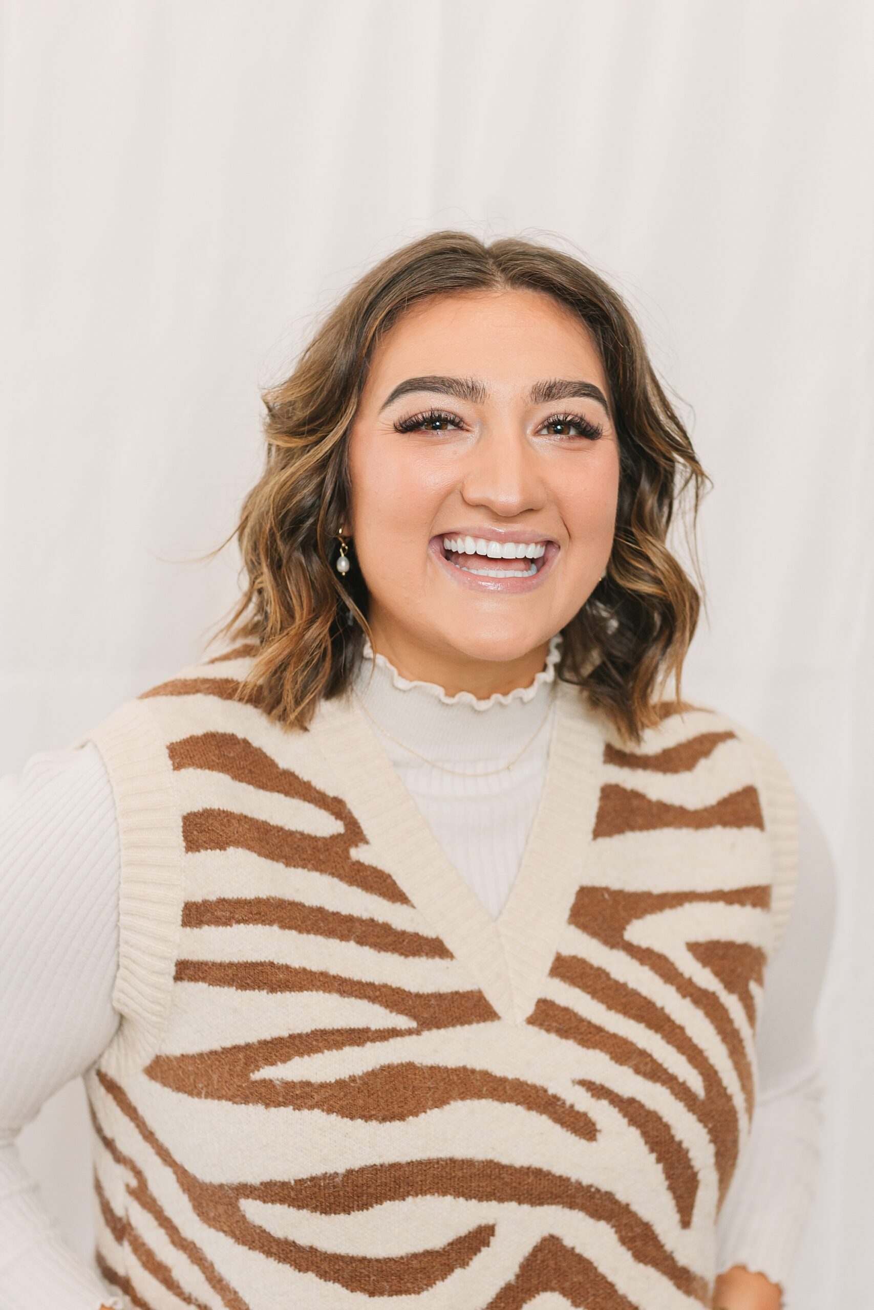 woman in zebra striped vest laughs during quarterly branding portraits in Nashville for salon