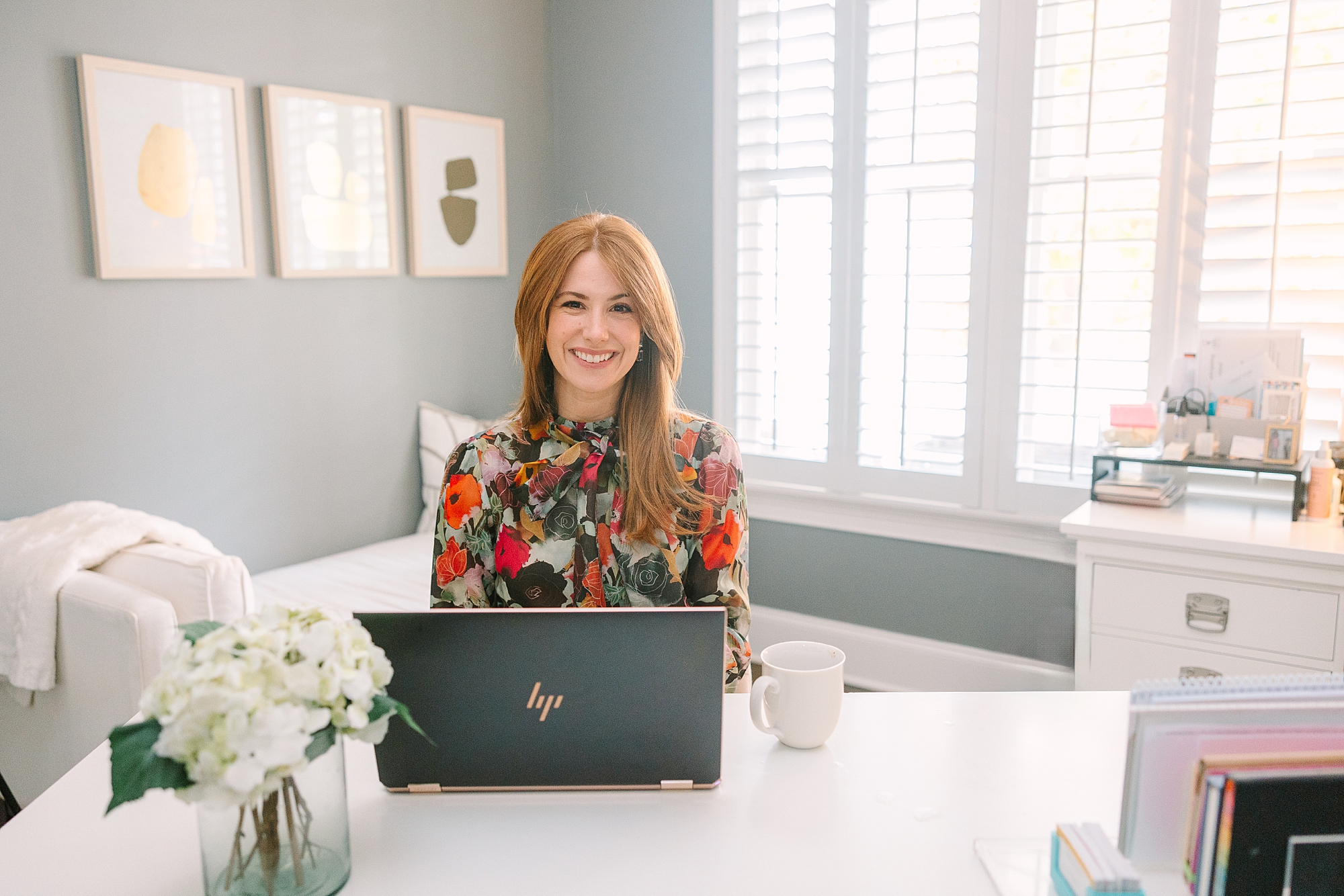 redheaded woman sits at kitchen table working laptop during quarterly Nashville branding session