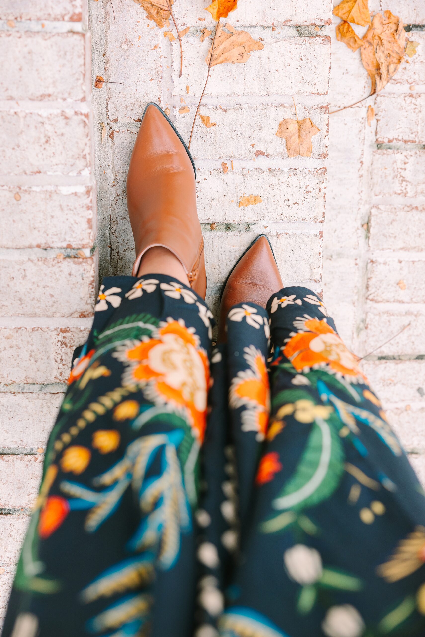 black dress with floral pattern with brown boots