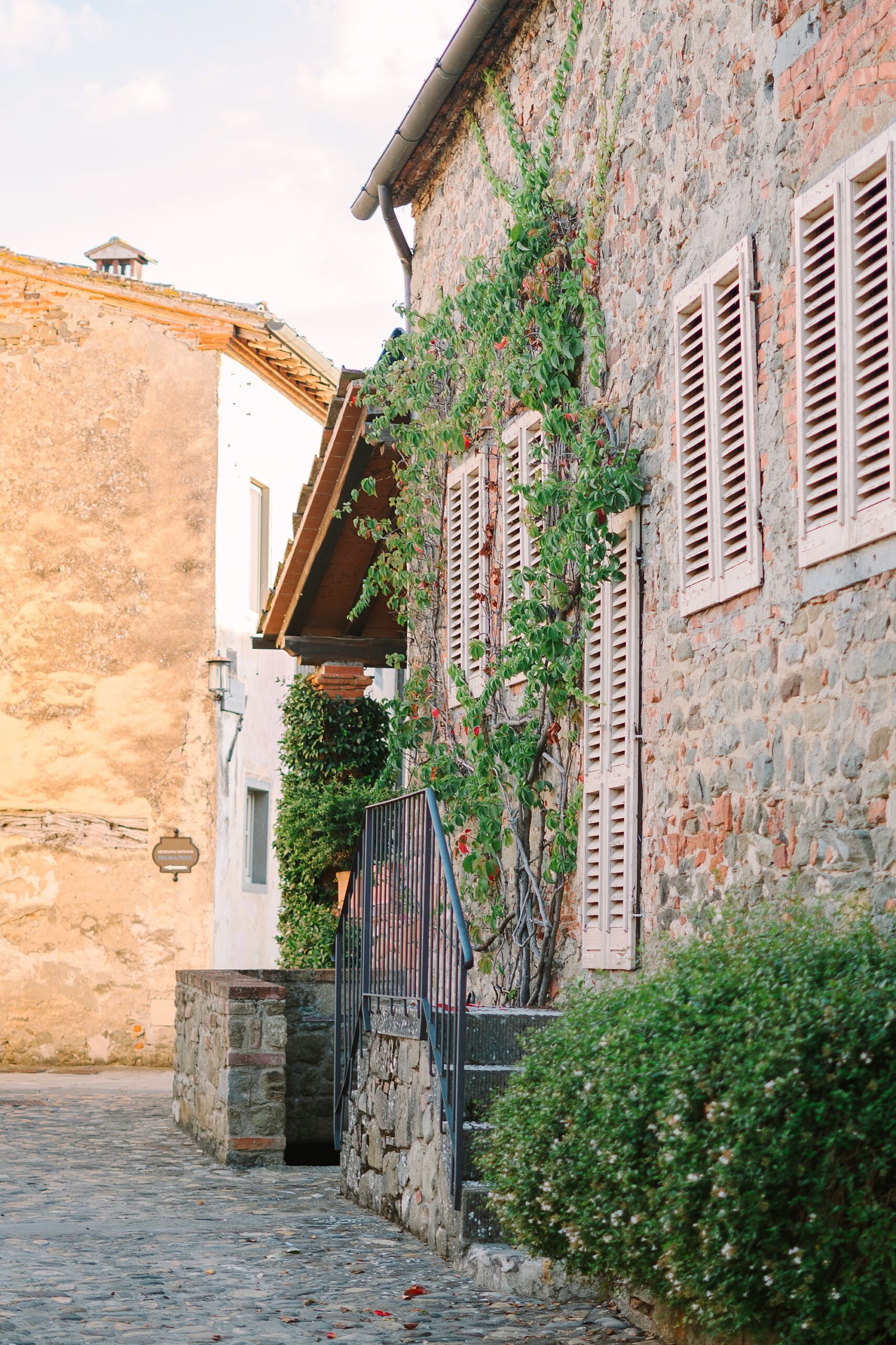 cobblestone streets and house lined in ivy in Italy
