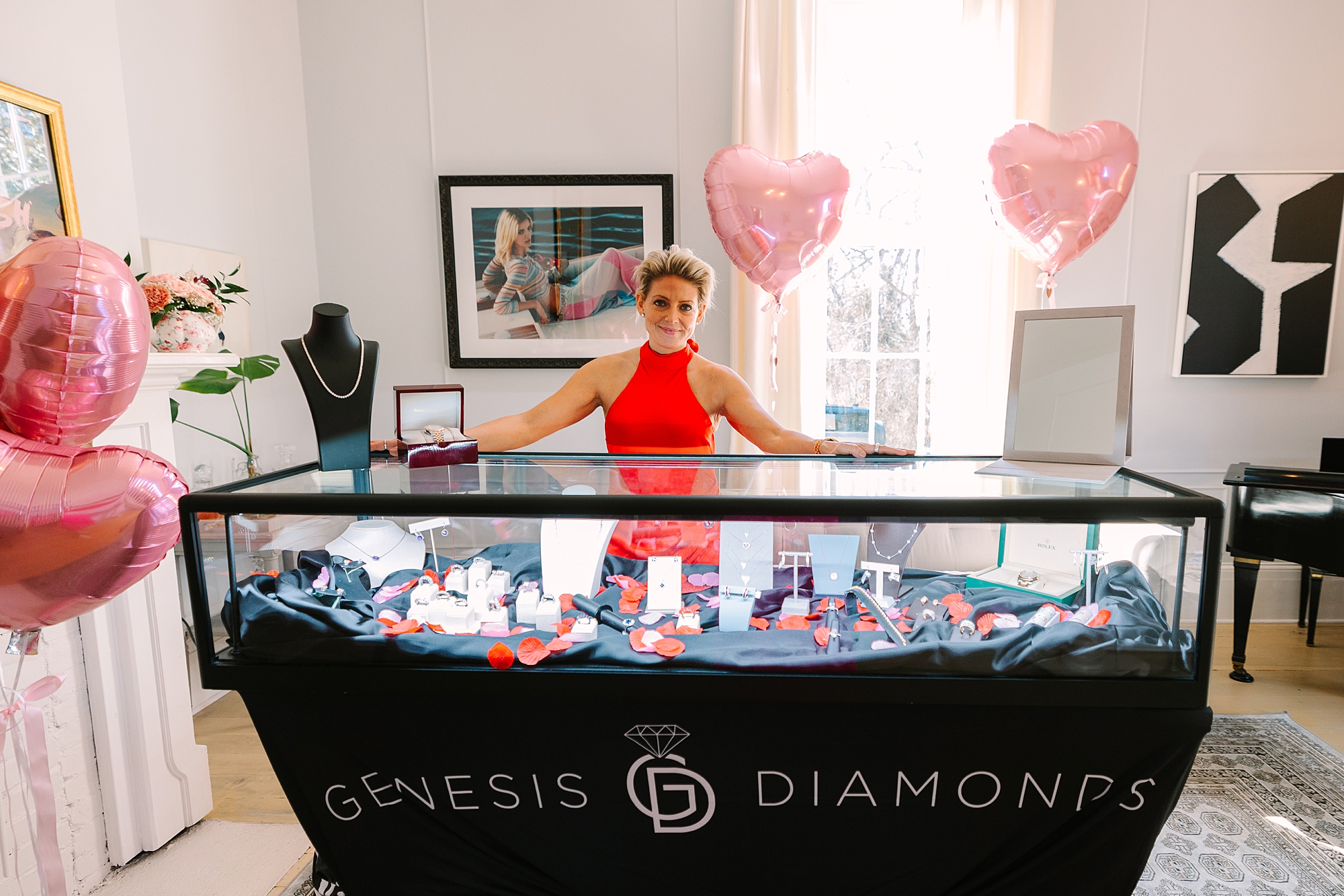 woman in red dress poses behind Genesis Diamond display