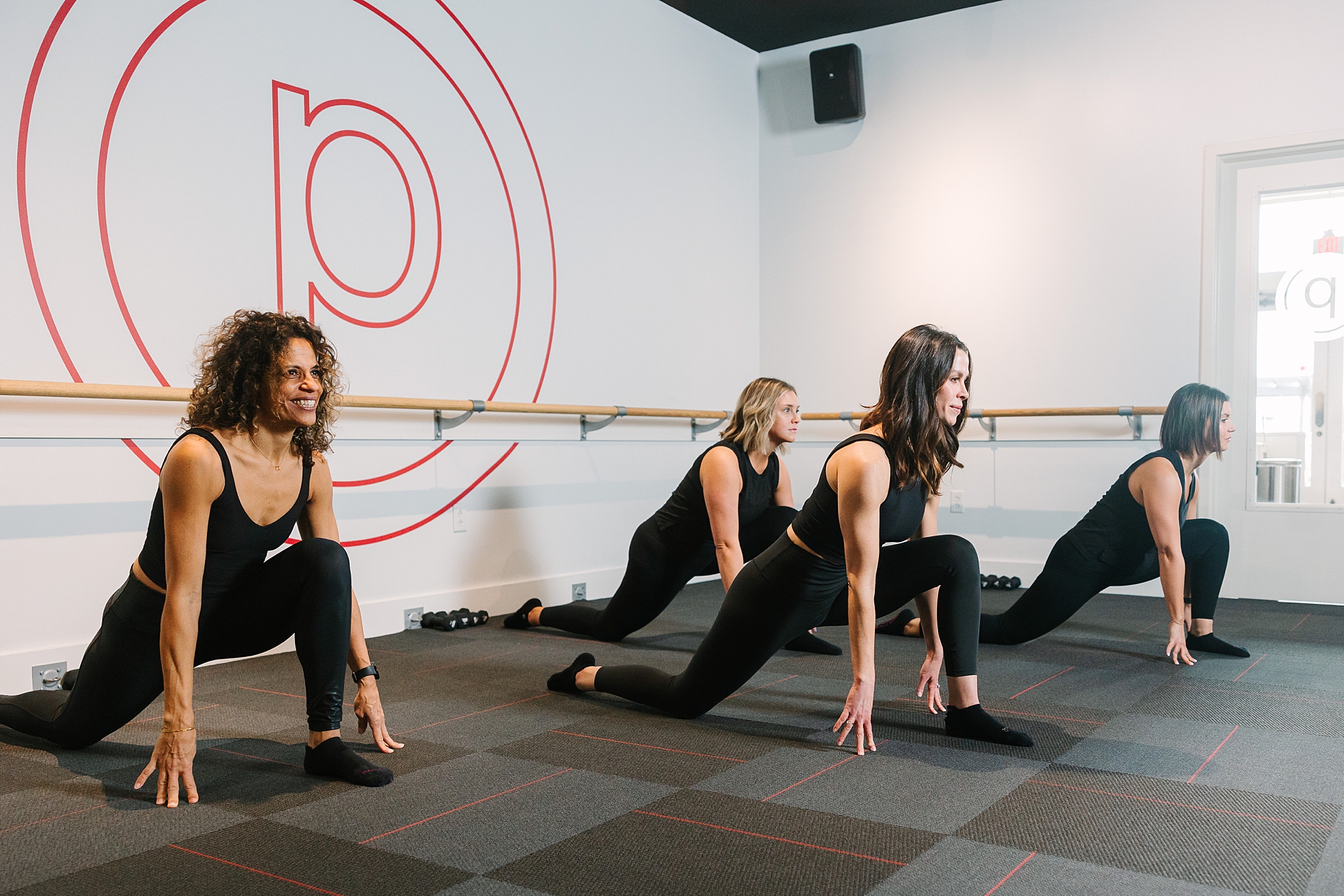 women kneel on ground during pure barre class