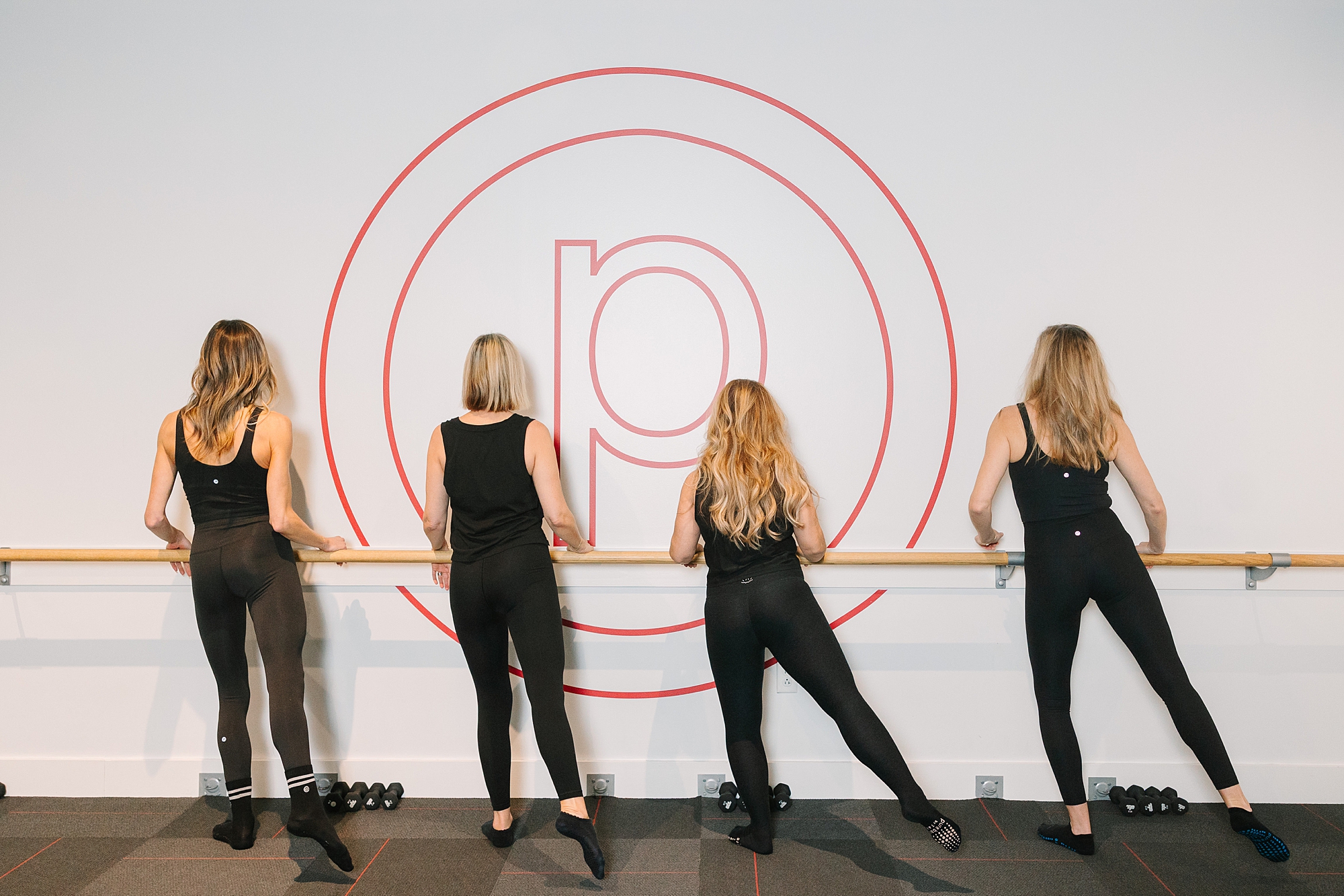 women lift leg holding barre during Pure Barre Westhaven
