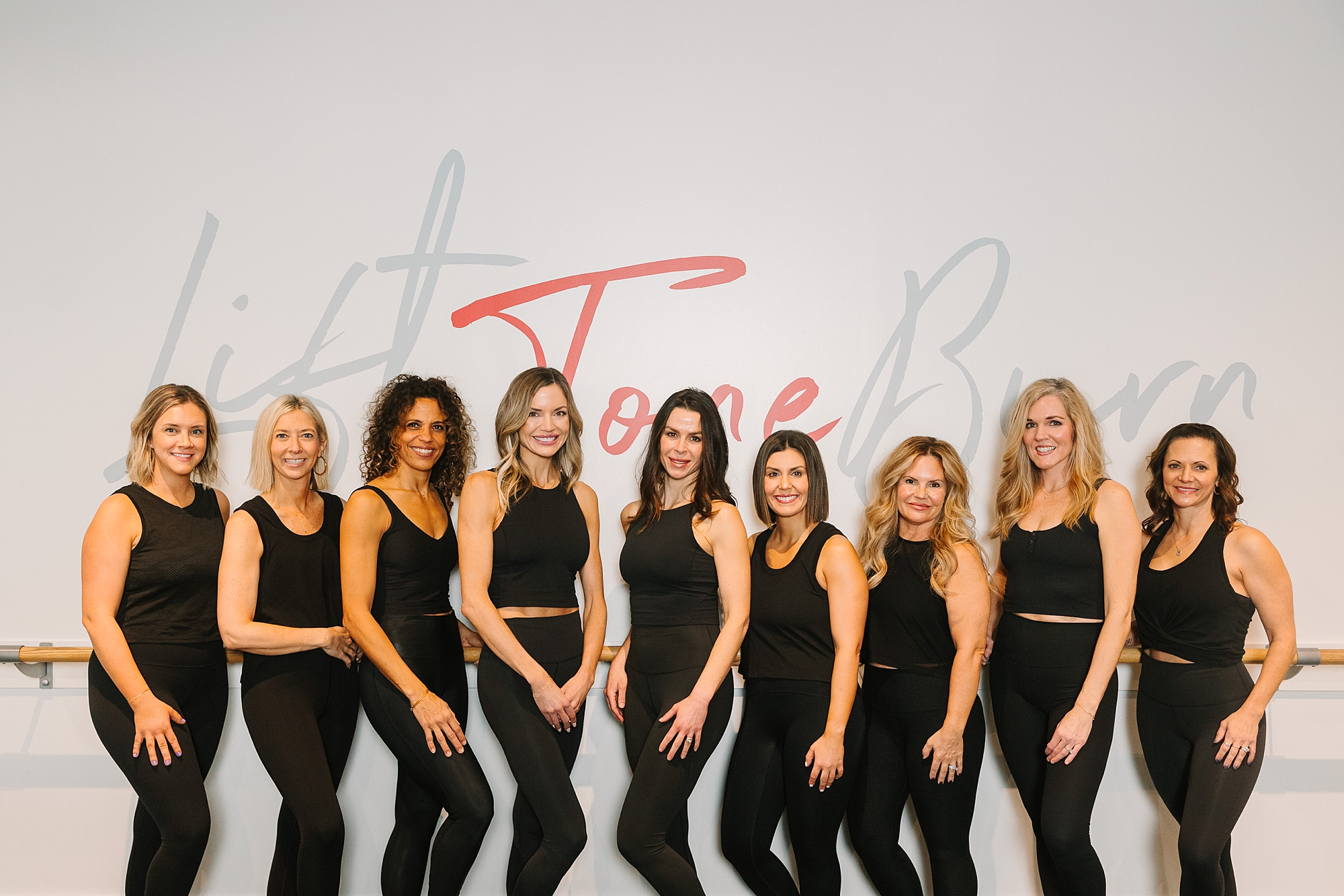 women line up by barre during fitness branding photos