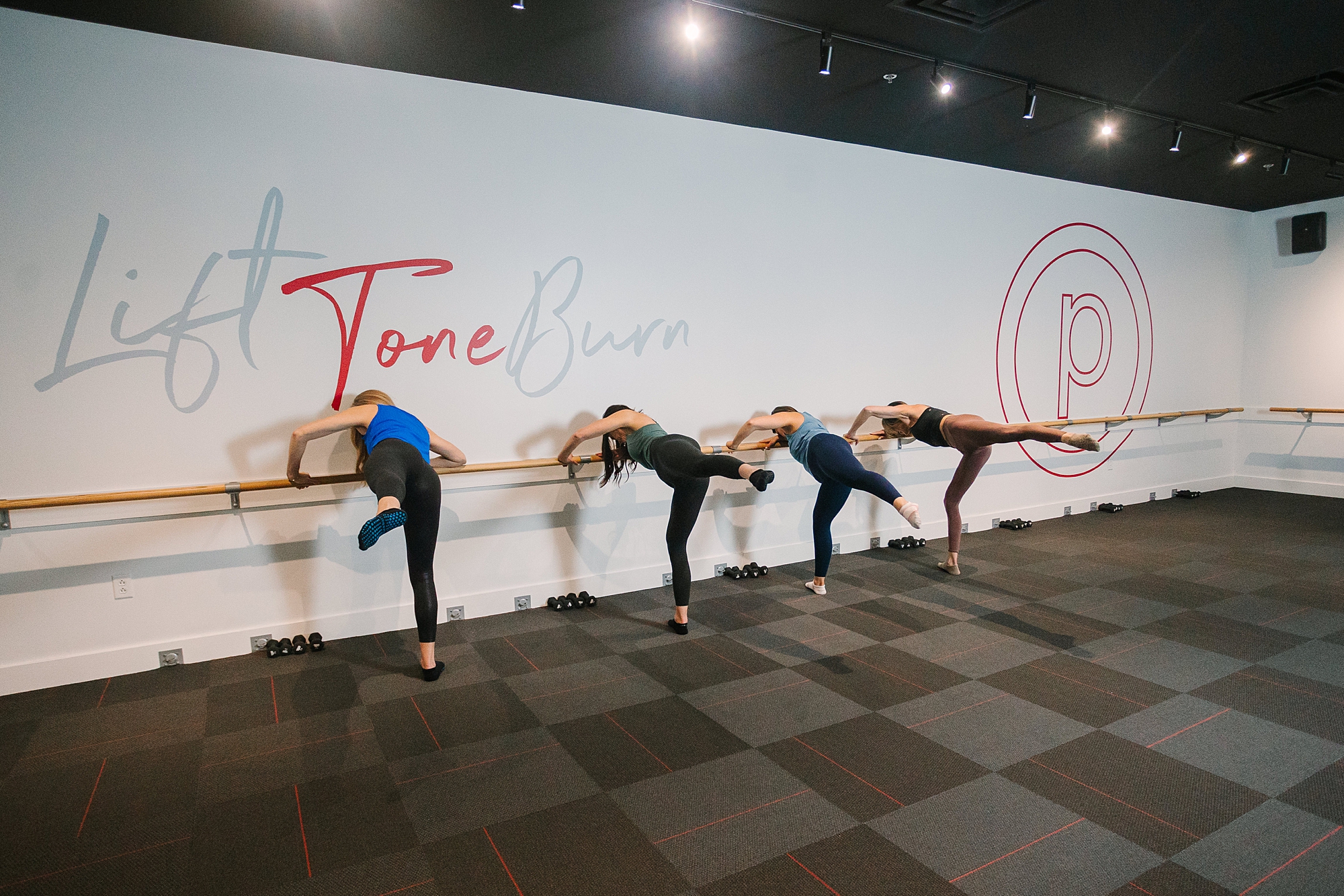 instructors lean over barre during fitness branding photos