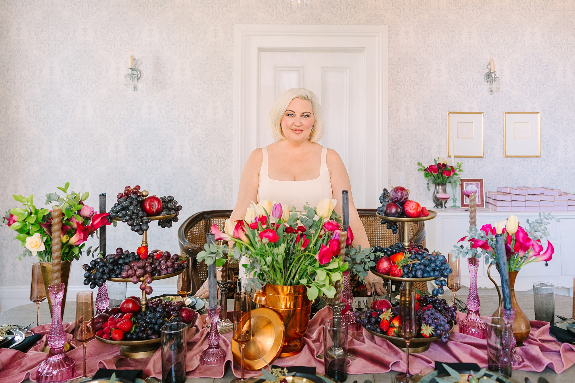 blonde woman poses behind table setup for menu tasting at Magnolia Acres for Rose & Plum Living