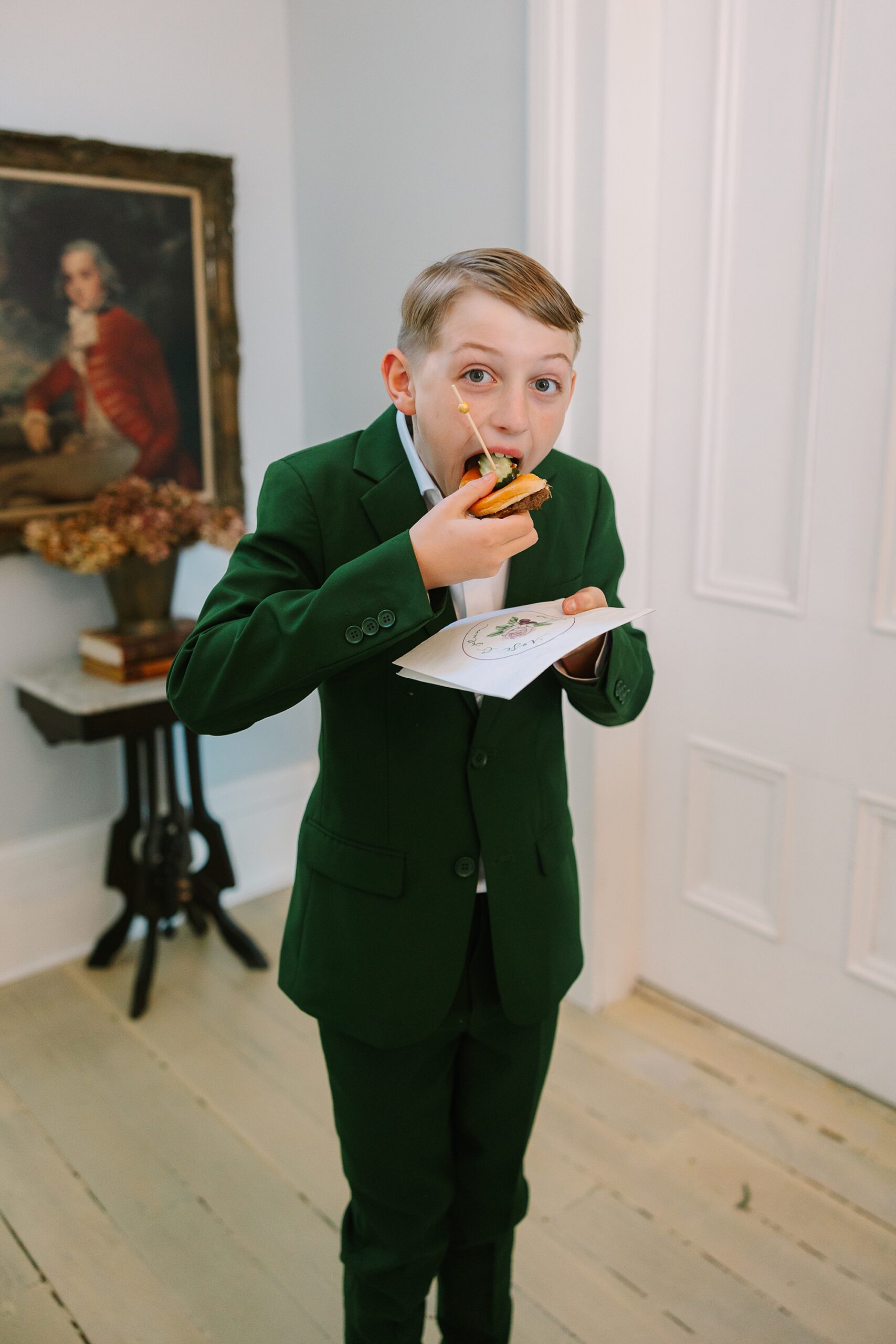 boy eats appetizer over napkin during menu tasting at Magnolia Acres for Rose & Plum Living